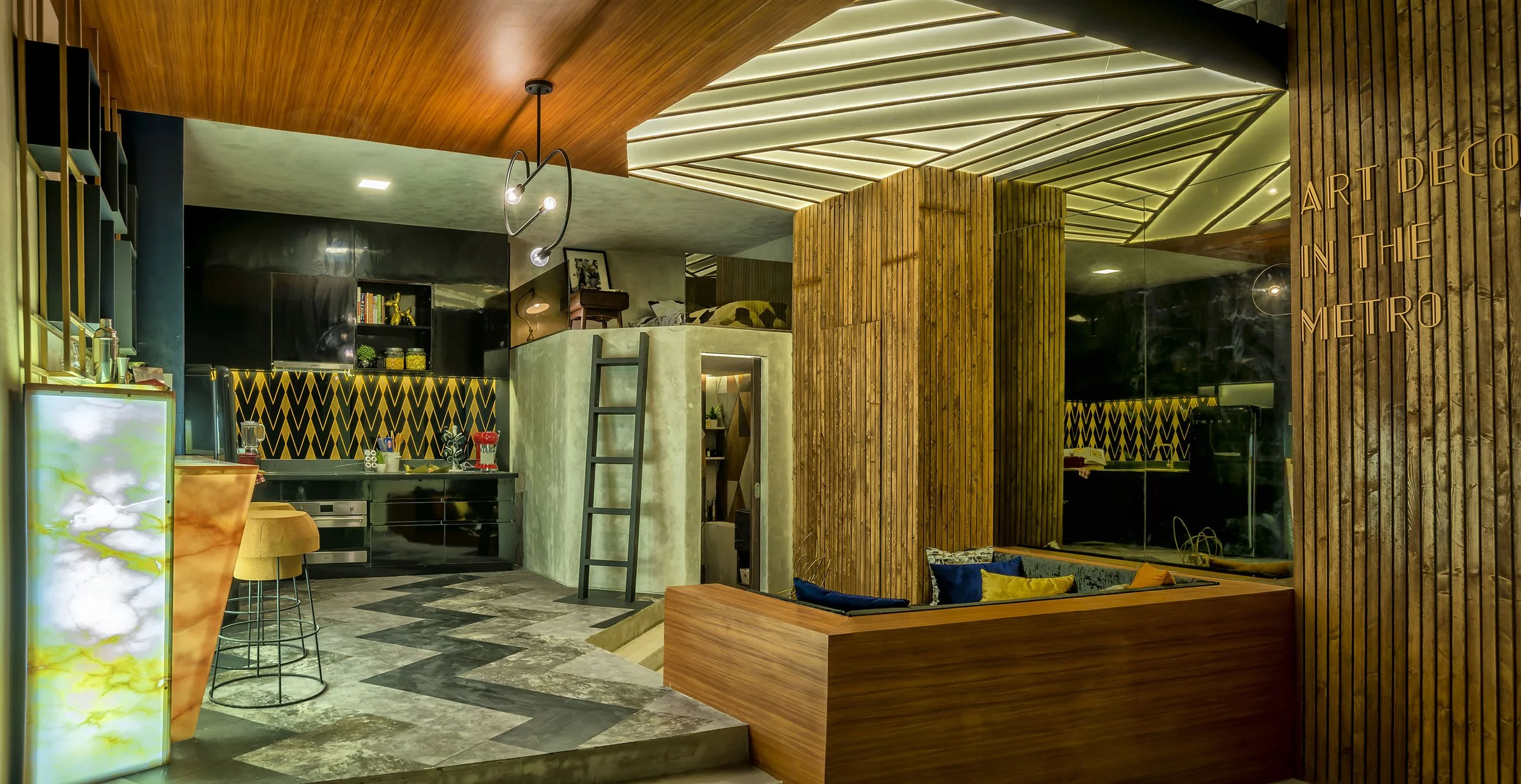 Modern interior with wooden walls and ceiling, a loft bedroom, and a patterned black and yellow backsplash in the kitchen area.