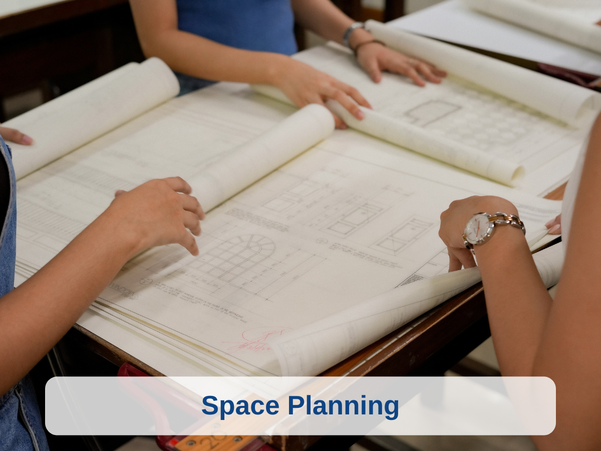 People examining architectural blueprints related to space planning at a work table.