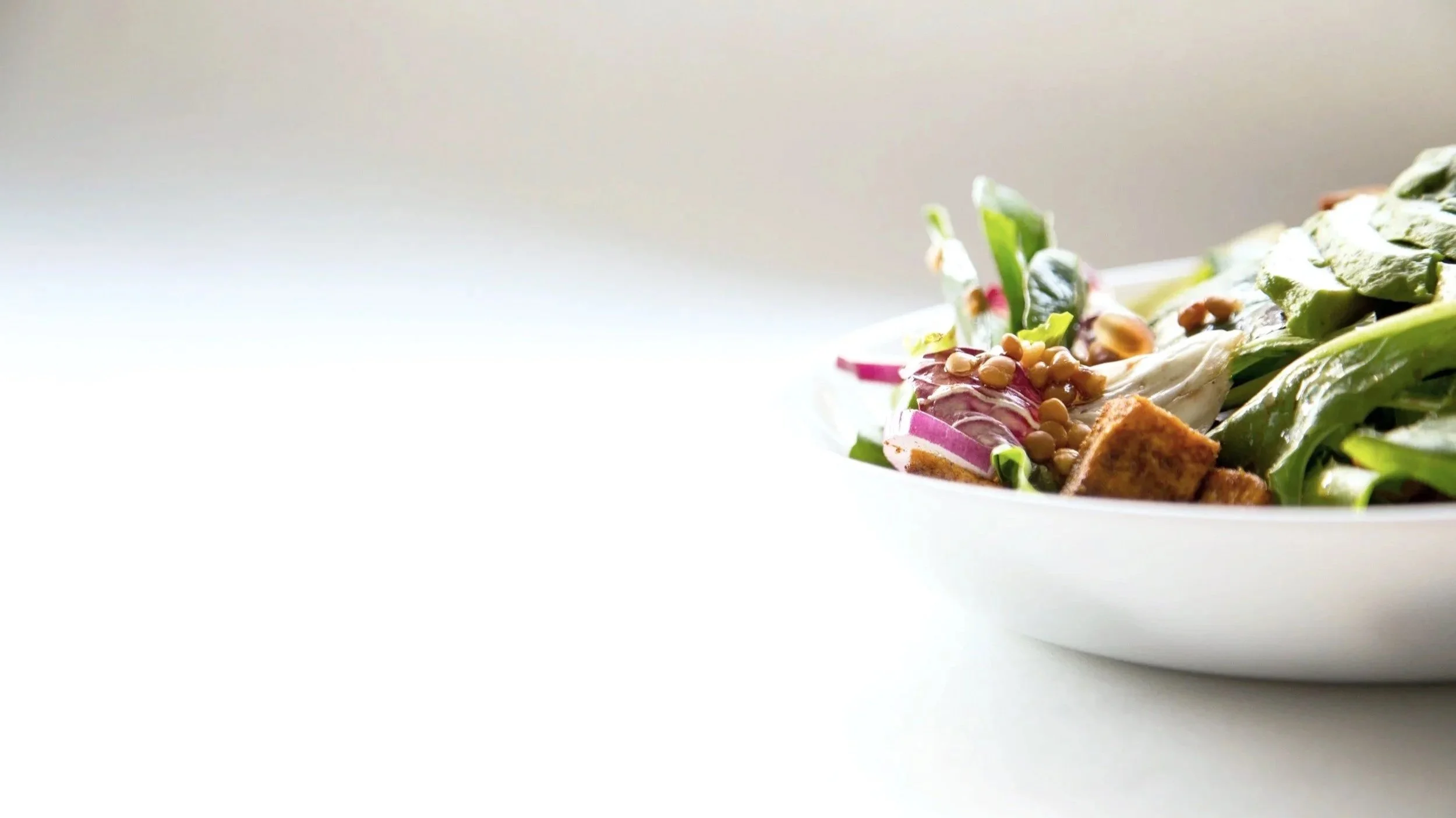 Bowl of salad on a table ready to eat.
