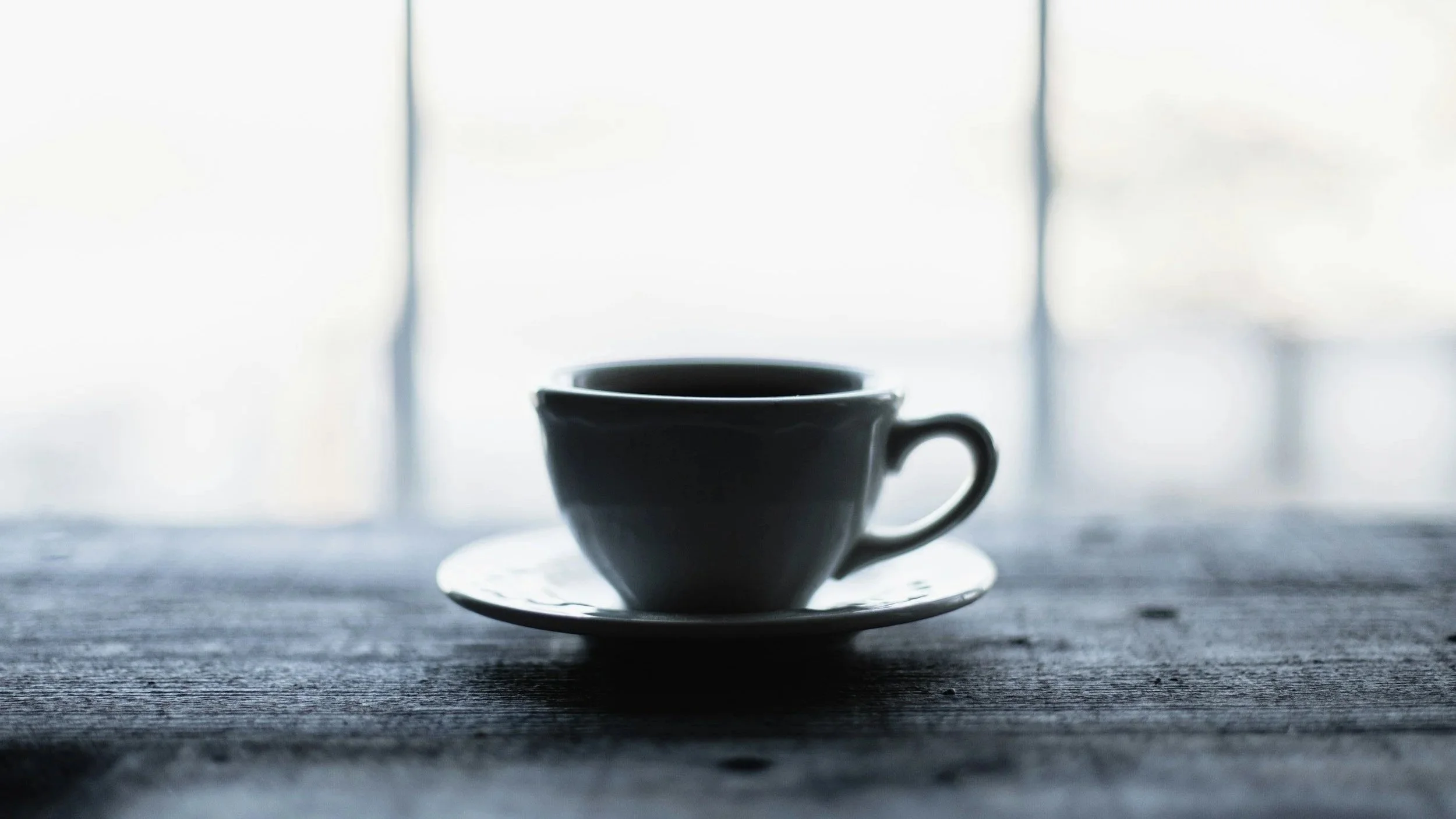 A cup of coffee at a quiet cafe looking out a window. Symbolising pulling inward and not always being available to others.