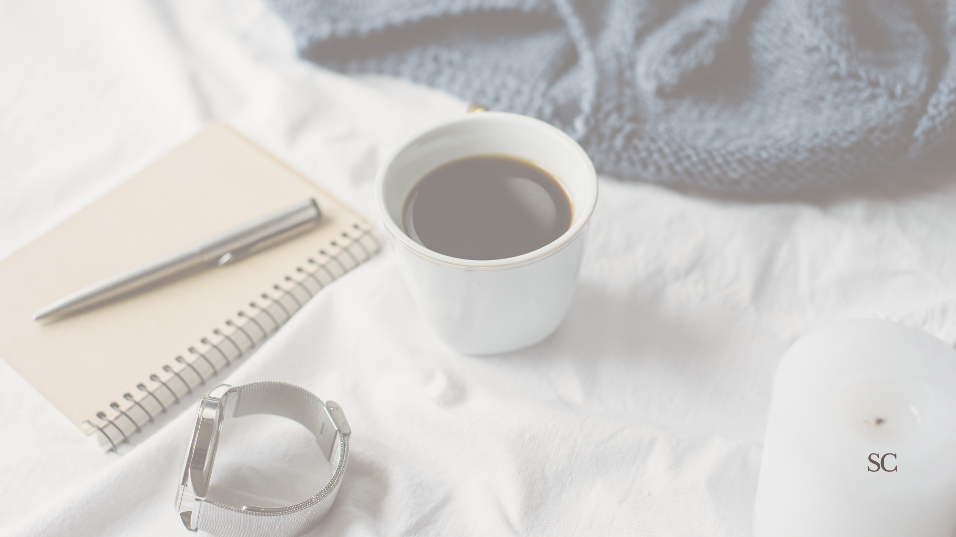 A minimal flat lay with a checklist and candle, inviting a slower pace.