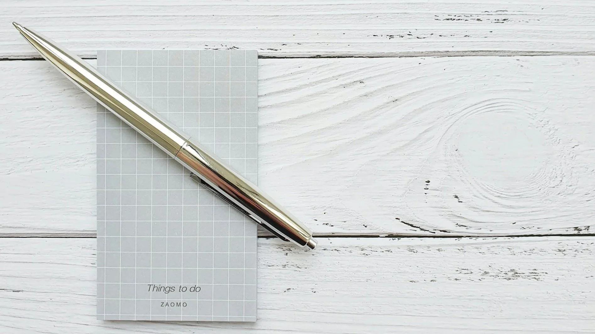 ne pen placed neatly beside paper representing simplicity & restraint.