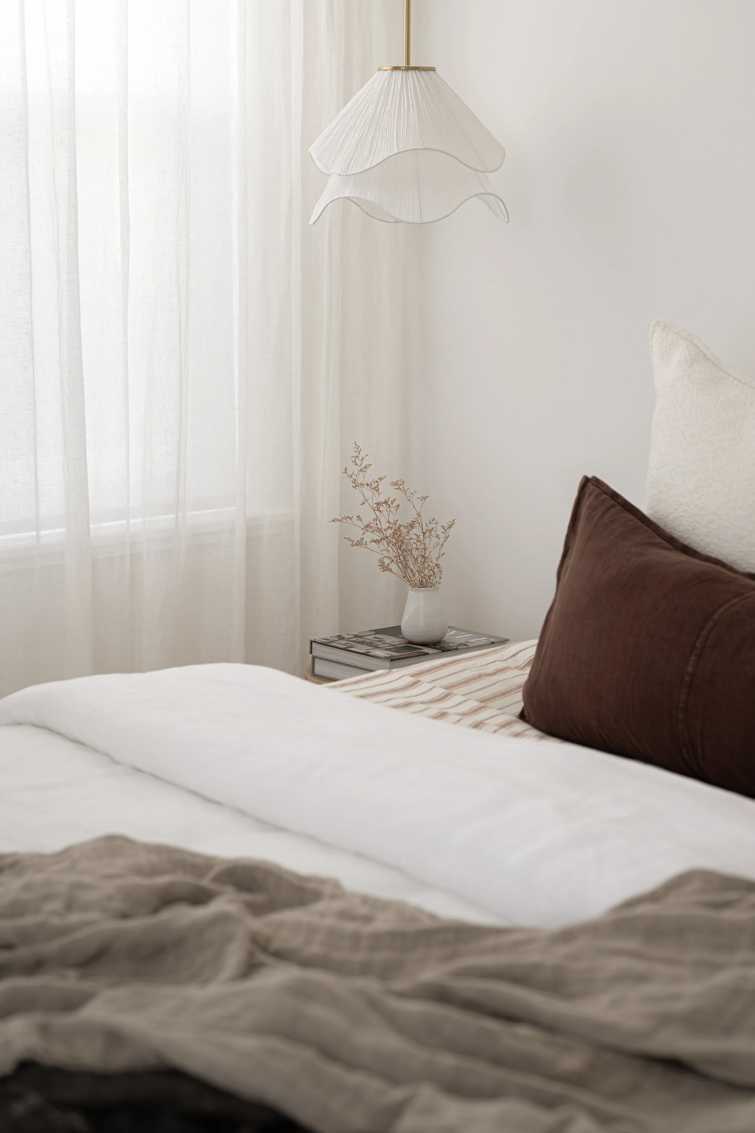 Bedroom corner with sheer linen curtains, sculptural pendant light, and brown velvet cushions, Glenelg Retreat, Young & Co Interiors