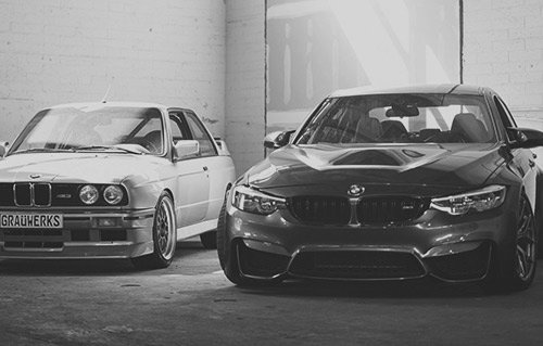 Two luxury sports cars parked side by side in monochrome style.