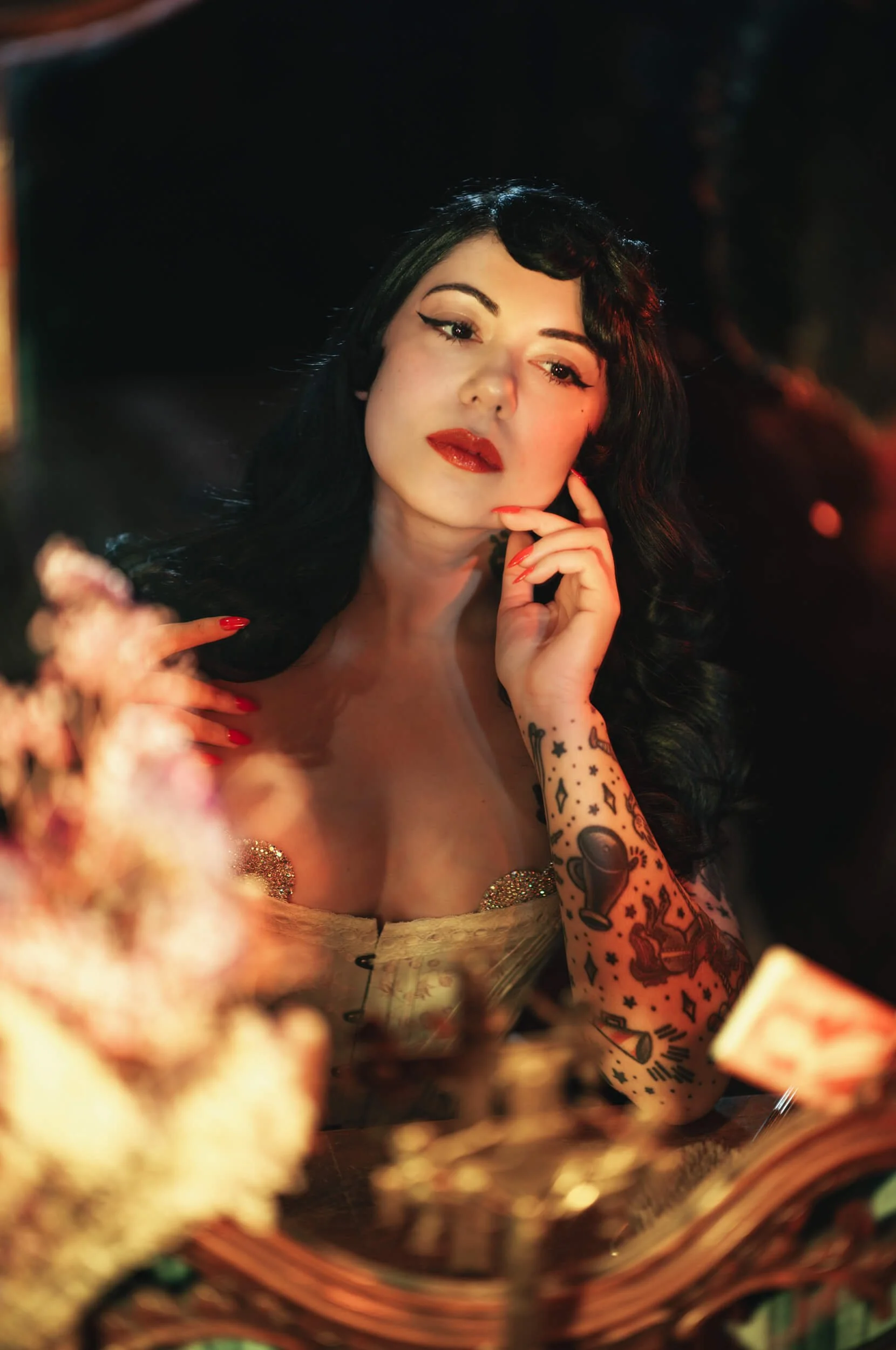 Bettie From Hell photographed with the Thypoch Simera 75mm f/1.4 on the Leica M11-D, with warm foreground reflections and red accent lighting.