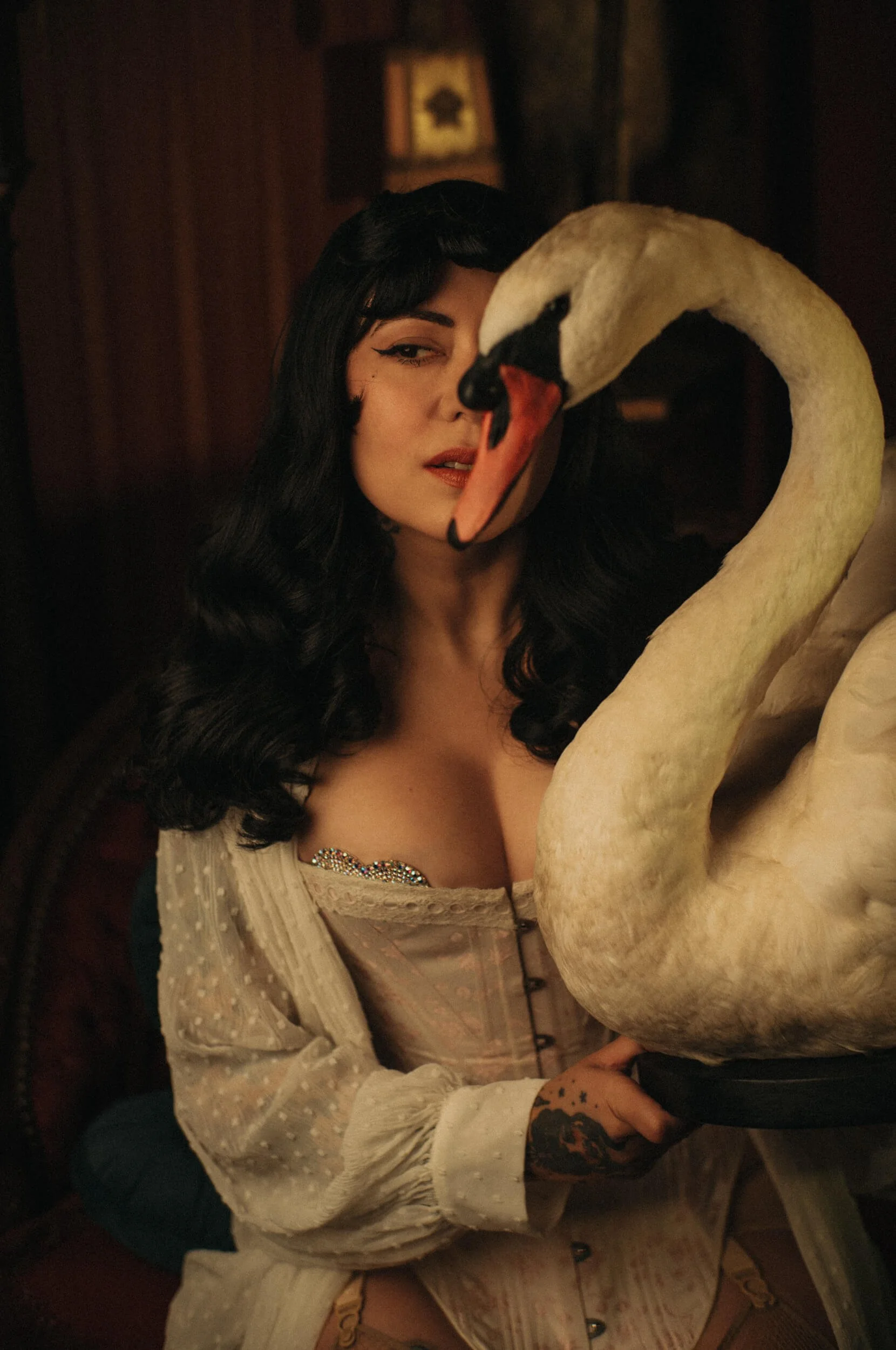 Bettie from Hell posing with a white swan prop in a cinematic portrait photographed with the Mandler 50mm f/1.4 E46 Pre-A.