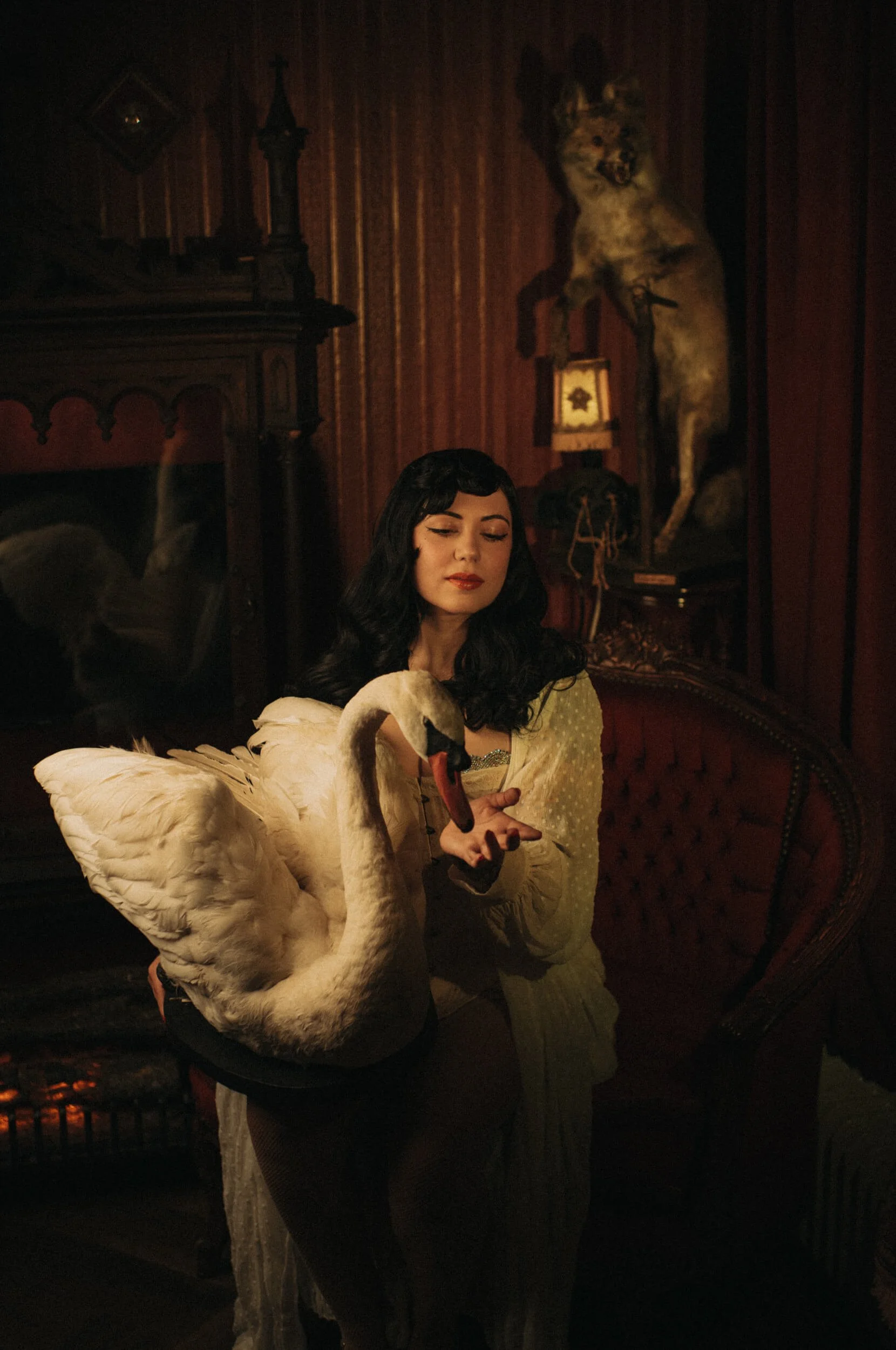 Bettie from Hell holding a white swan in a cinematic portrait photographed with the Mandler 50mm f/1.4 E46 Pre-A on the Leica M11-D.
