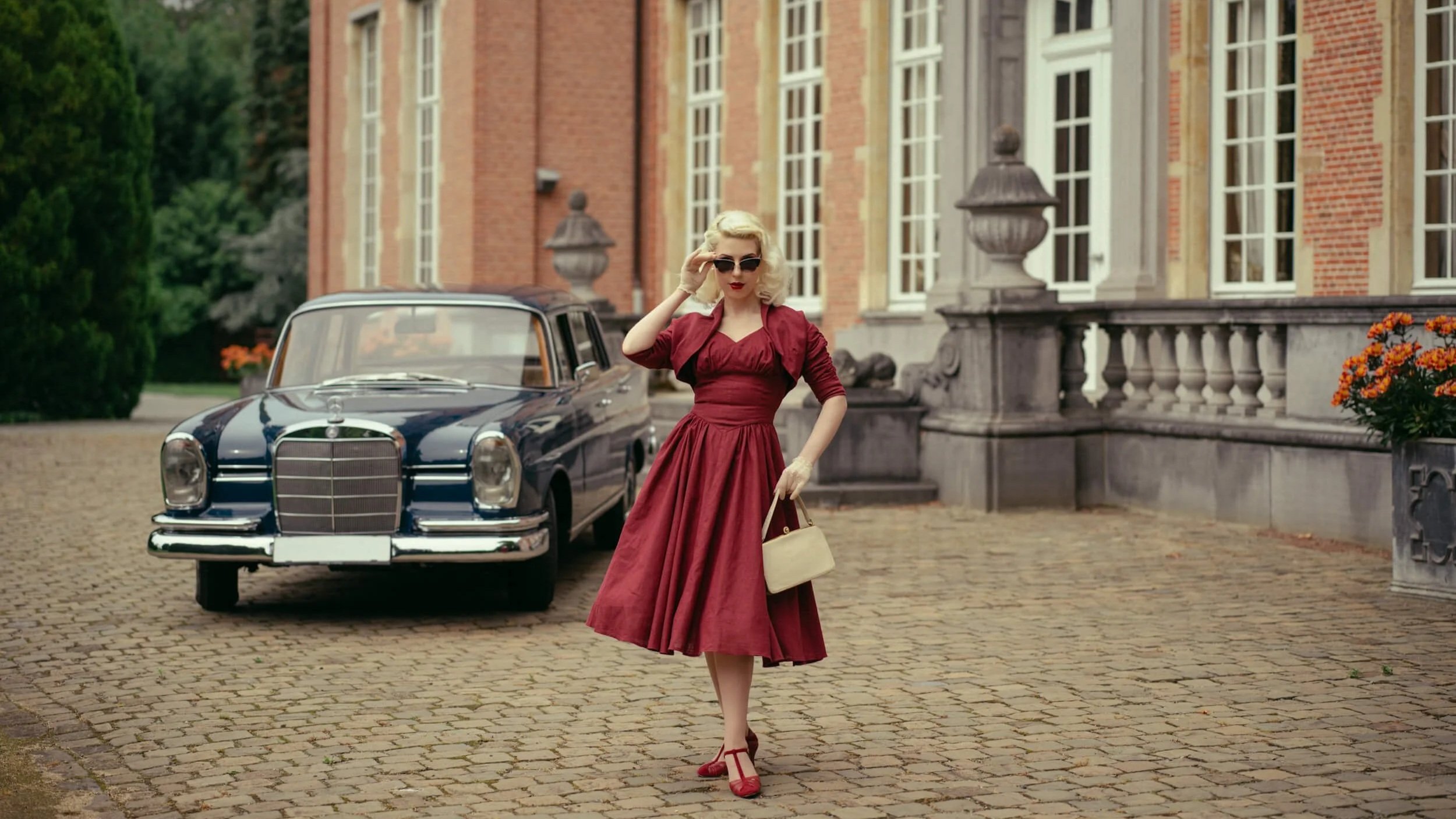 Yulia in a red dress standing beside a vintage Mercedes-Benz 220 shot with Hasselblad 907X 50C and XCD 80mm f1.9