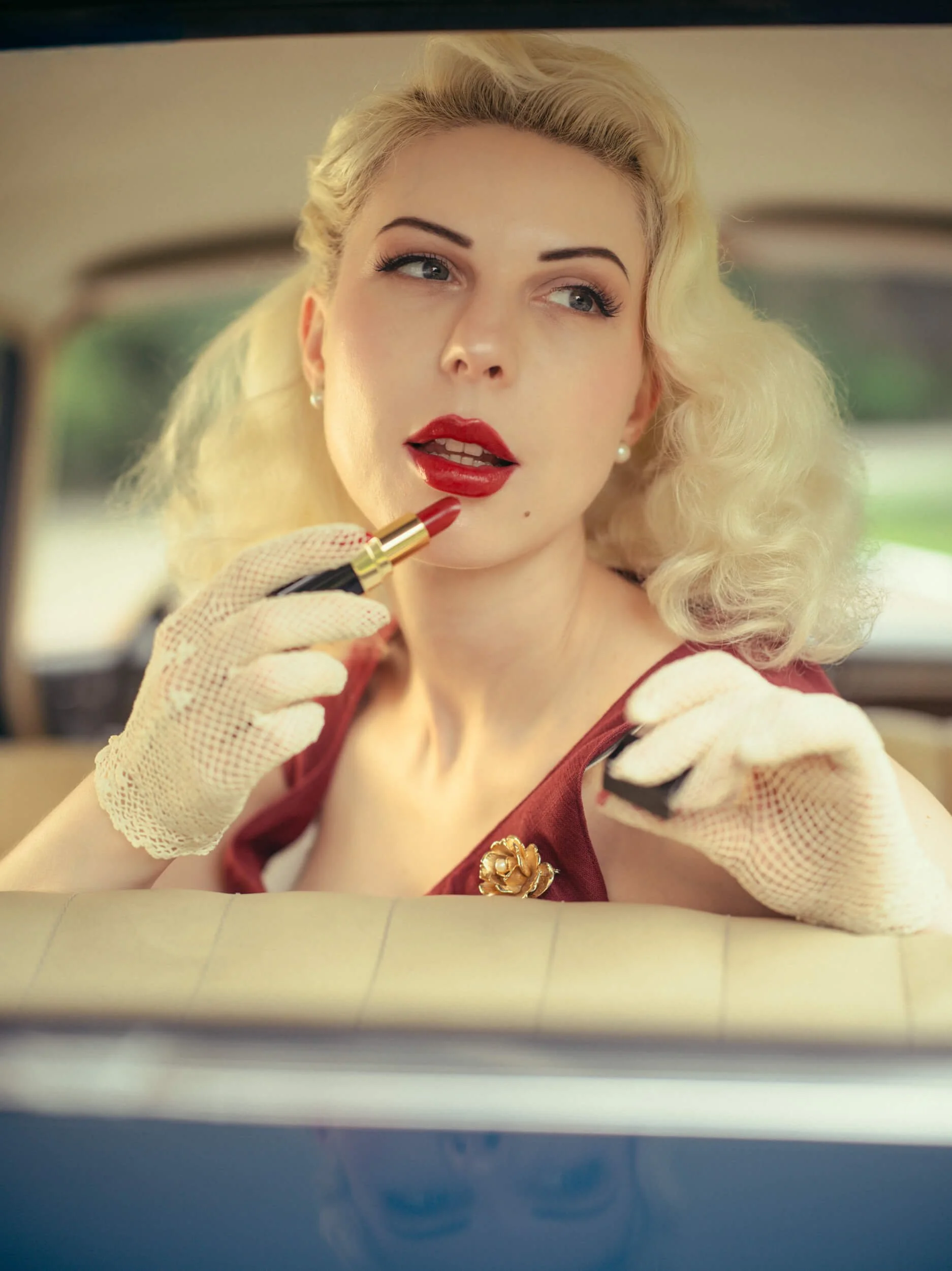 Portrait of Yulia with red lipstick inside a vintage Mercedes-Benz 220