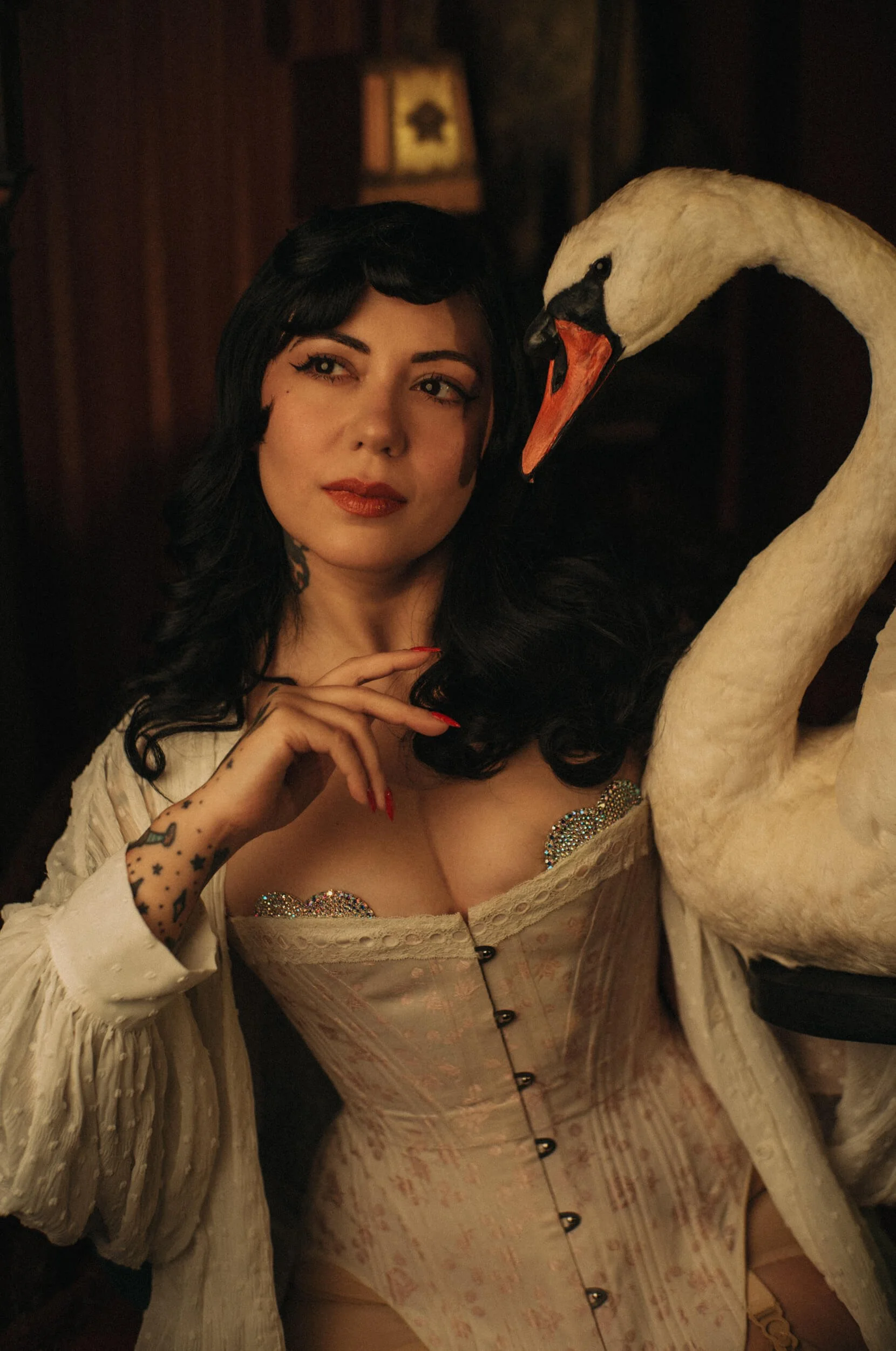 Cinematic portrait of Bettie from Hell posing with a white swan, photographed with the Mandler 50mm f/1.4 E46 Pre-A lens on a Leica M camera.