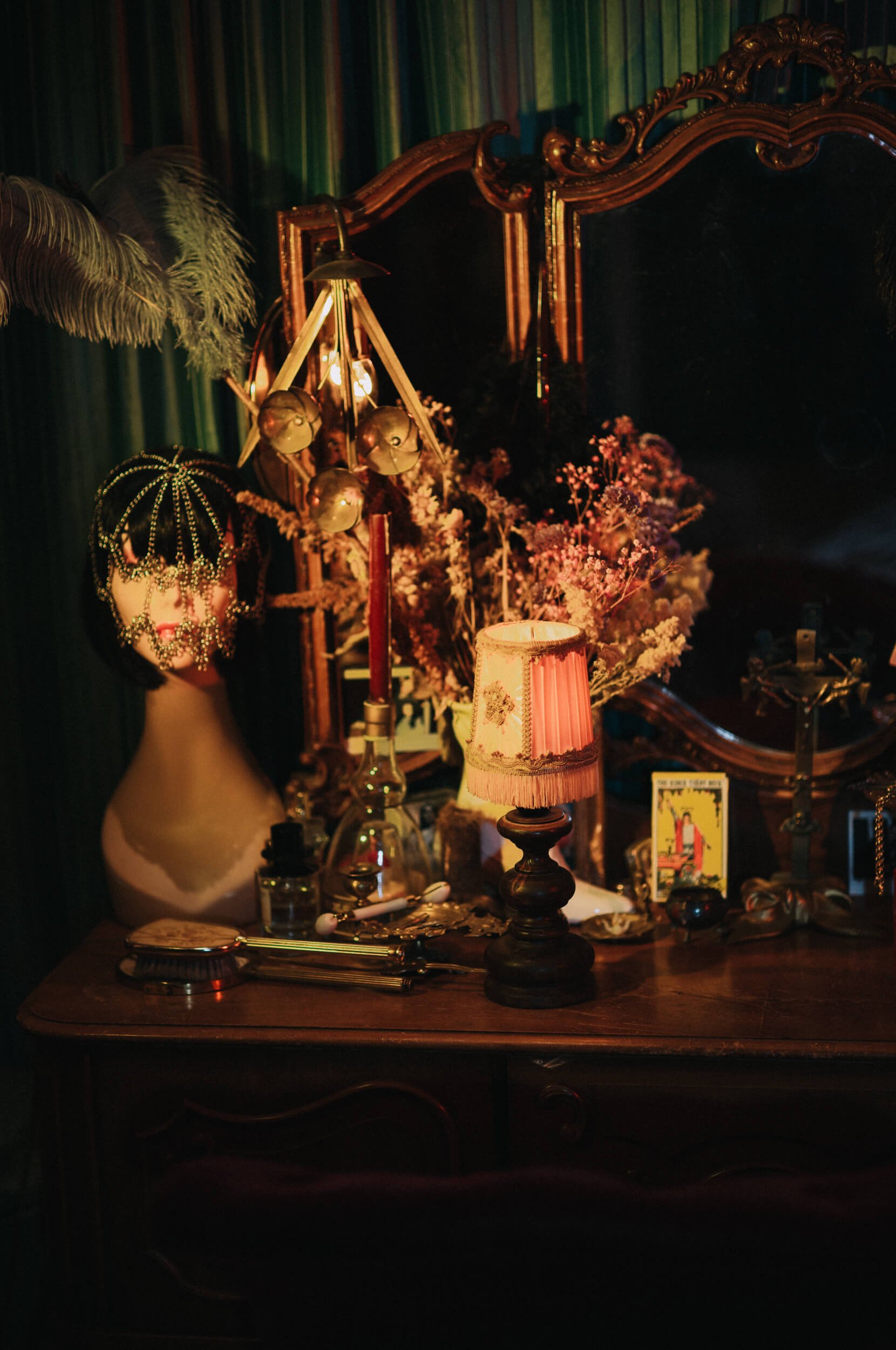 Night-time still life photographed with the Mandler 50mm f/1.4 E46 Pre-A, showing the lamp in sharp focus and the pearl details on a decorative mannequin softly blurred in the background.