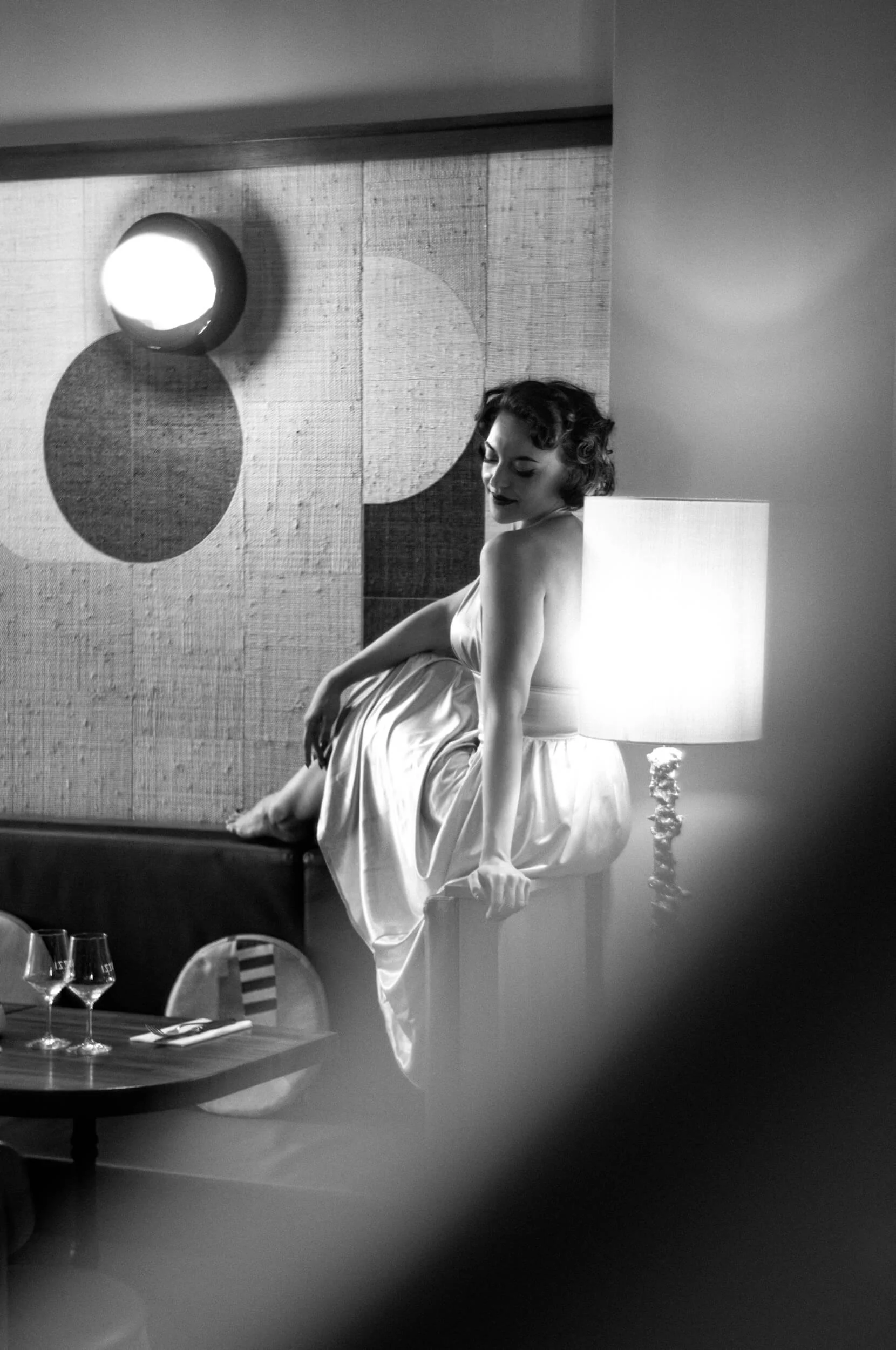 Black and white portrait inside a café showing the soft glow and tonal rendering of the Omnar Bertele 50mm f/2