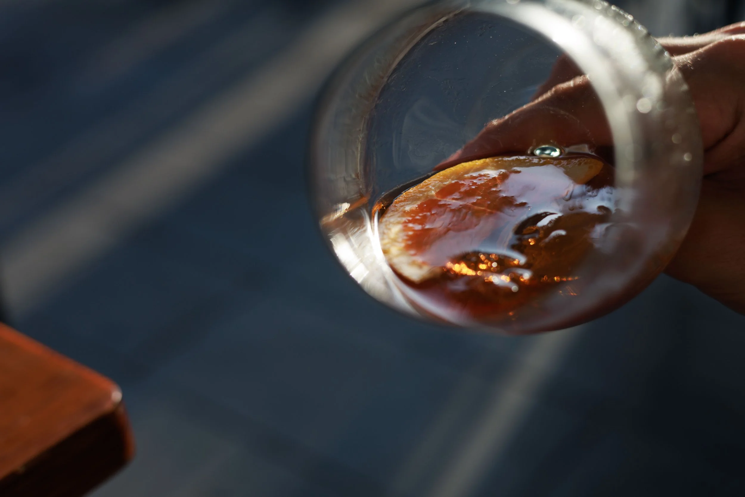 Vista dall'alto di un bicchiere di vino rosso con una fetta di arancia all'interno.