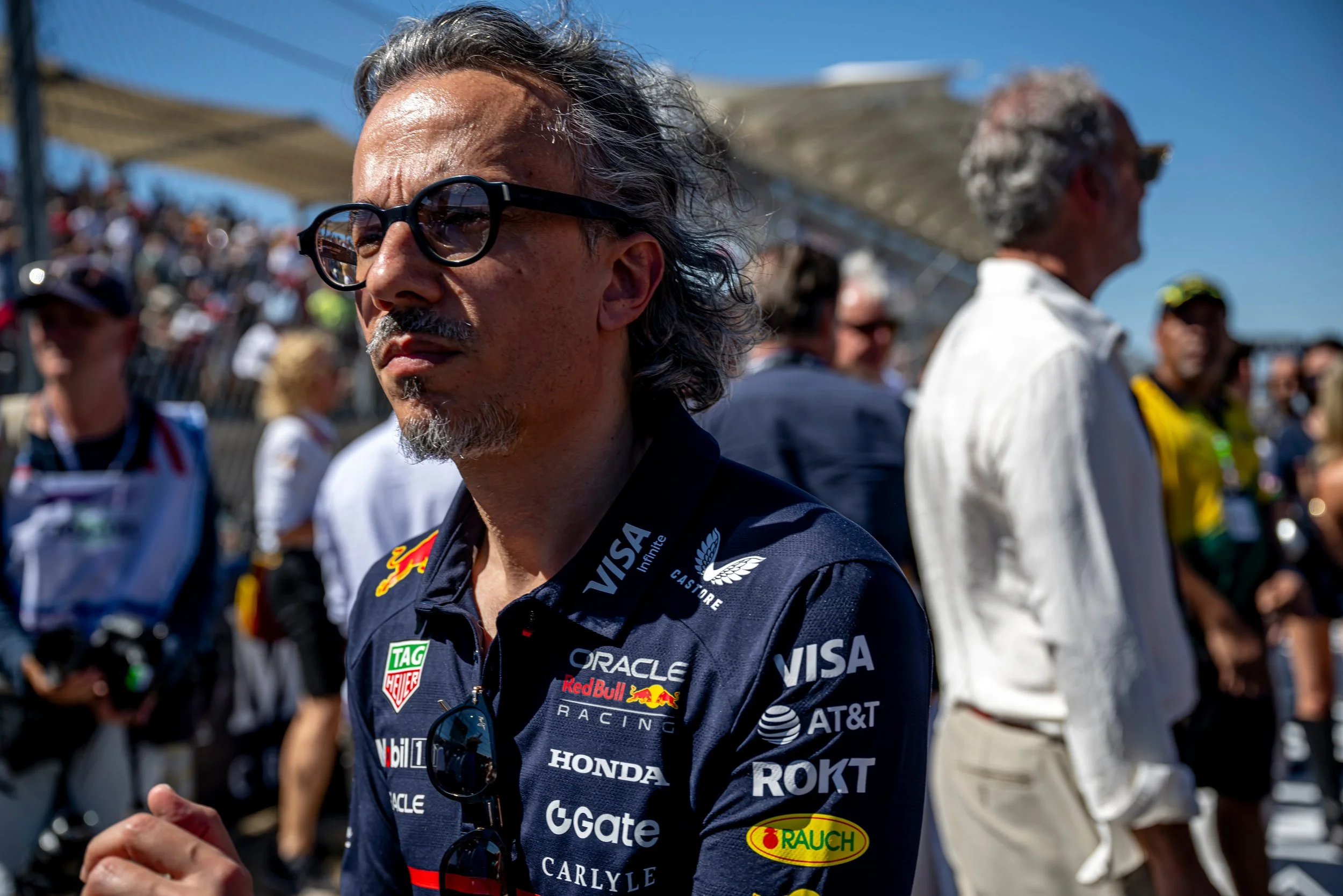 Red Bull Racing Team Principal, Laurent Mekies pictured at close range walking through a busy F1 grid.