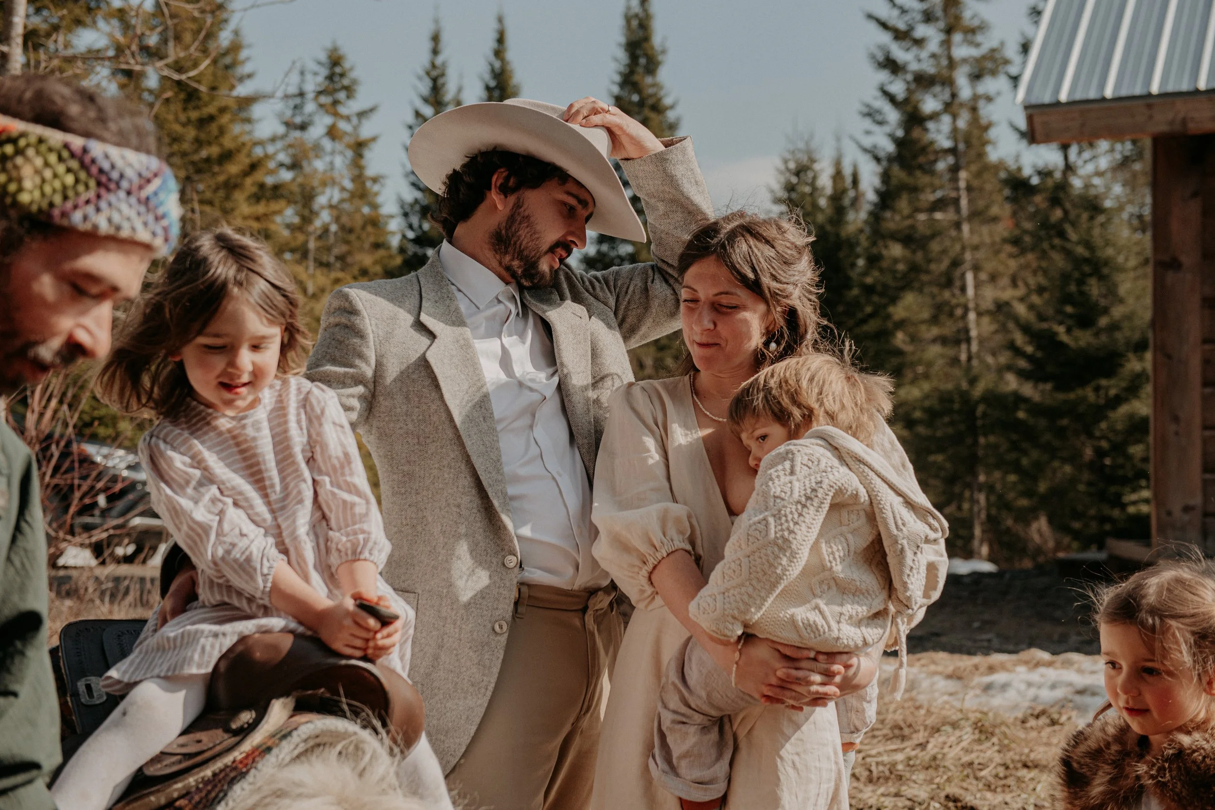 Une famille se rassemble à l'extérieur, avec des arbres en arrière-plan, lors d'une journée ensoleillée.