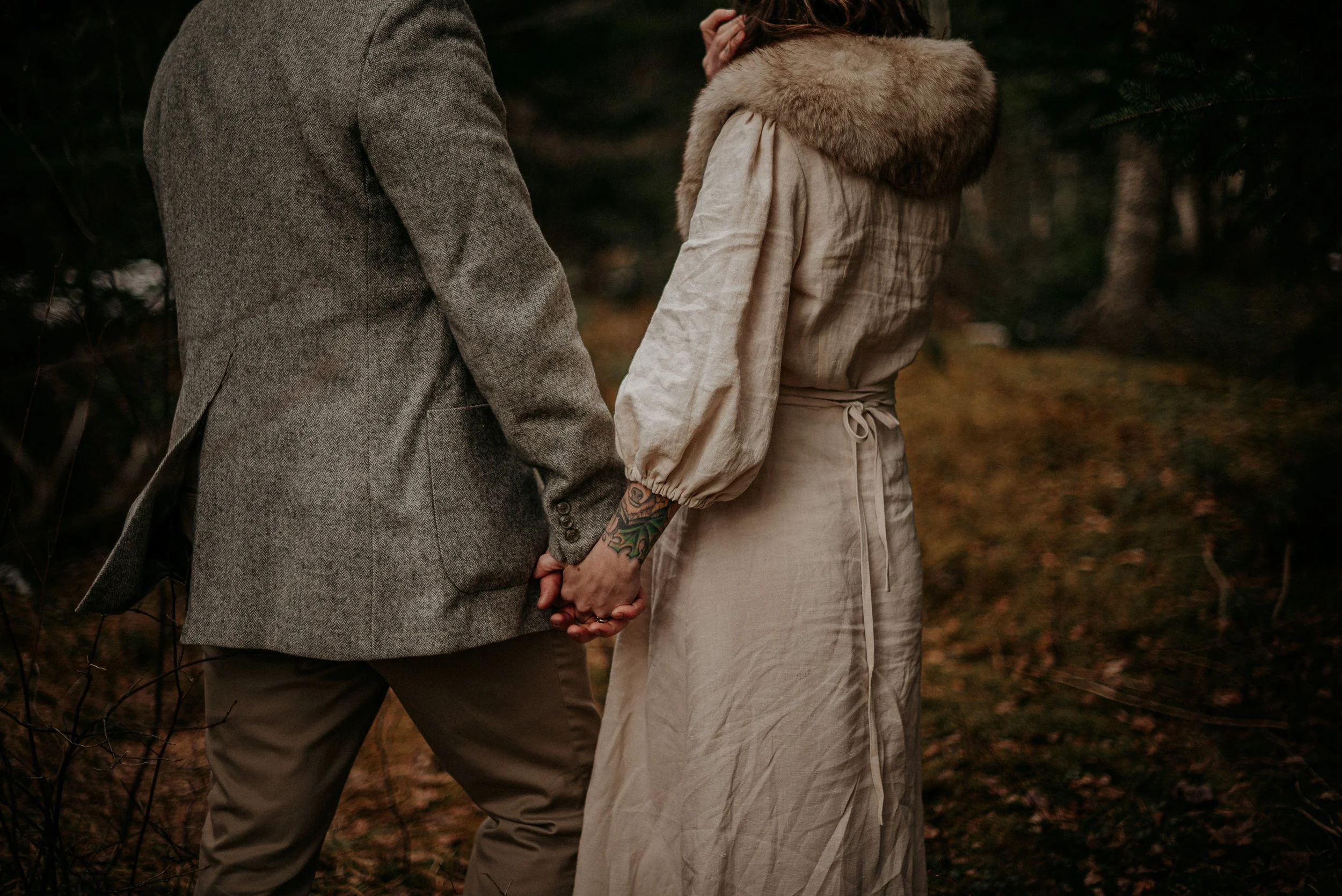 Portrait d'un couple venant de se marier tenant la main dans un environnement forestier en Estrie au Québec.
