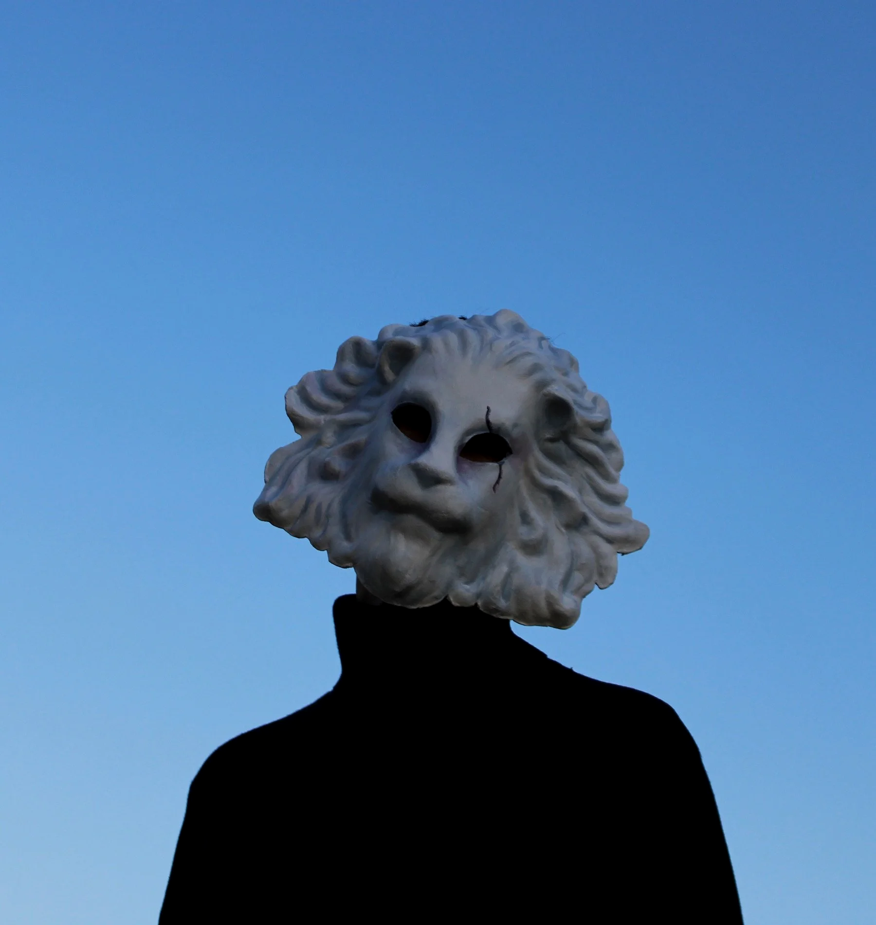 Autoportrait de Galanka, figure masquée se détachant sur un fond de ciel, apparition silencieuse liée à l’univers Wildate.