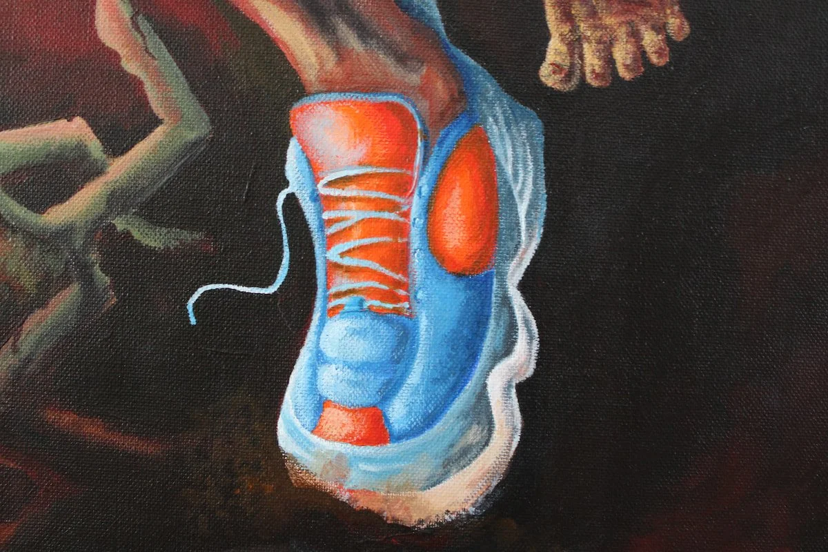 Détail d’un pied chaussé peint sur fond sombre.