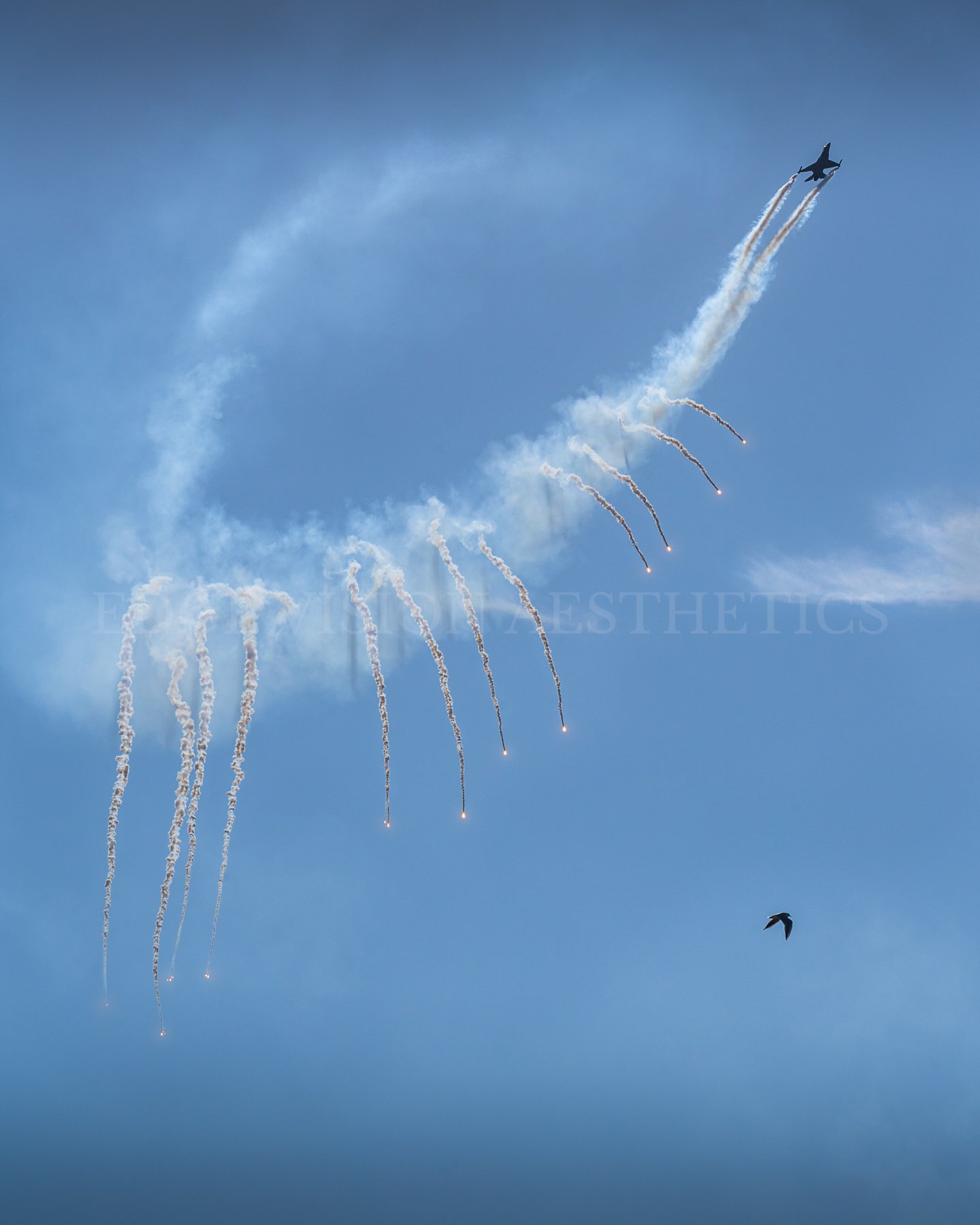 An aircraft flying in the sky releasing smoke trails and fireworks.