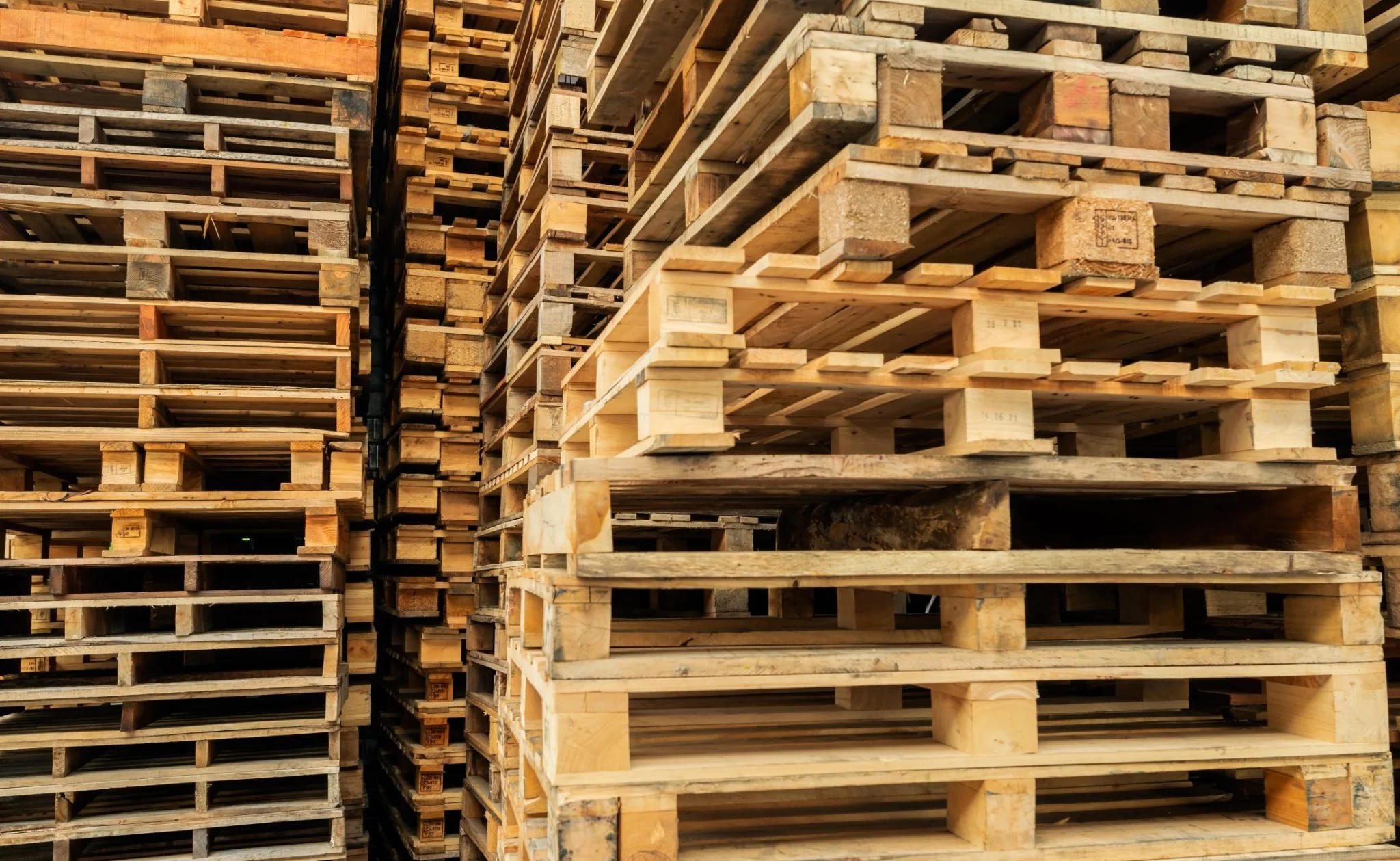 Stacks of wooden pallets in a warehouse.