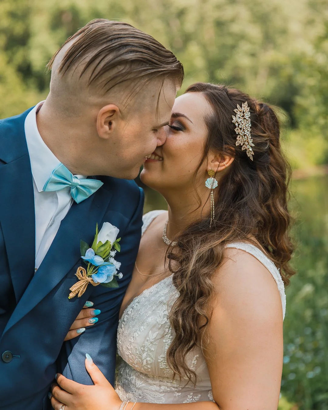 Häät, pari suutelee luonnonhelteisessä ympäristössä.