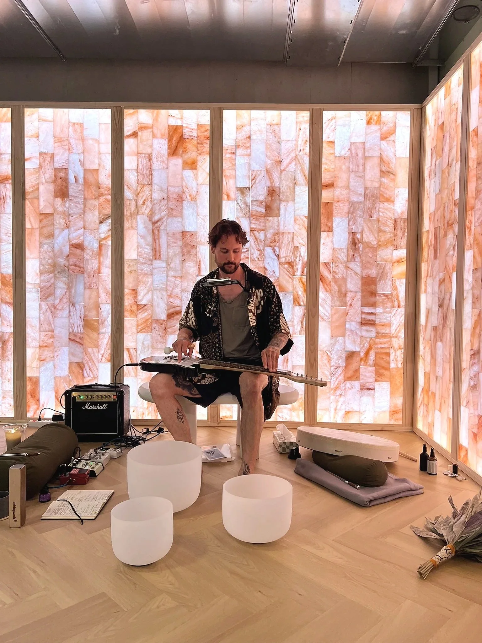 Tino playing live musical instruments: guitar, crystal bowls, drums for deep relaxation during Sound Escape at ANNTIN studio in Zurich Nord.