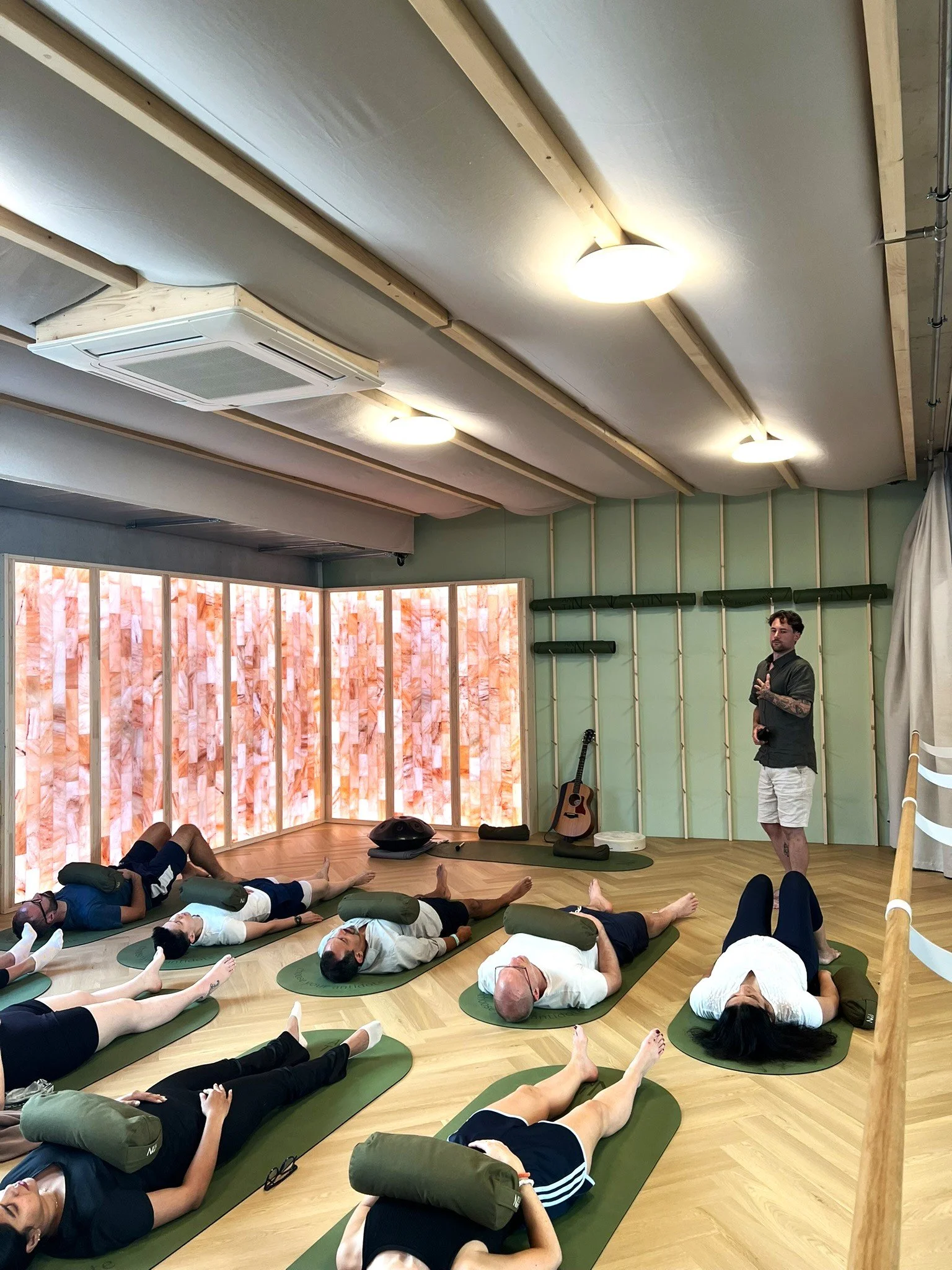Group relaxation and nervous system regulation class surrounded by glowing salt wall panels in Glattbrugg.