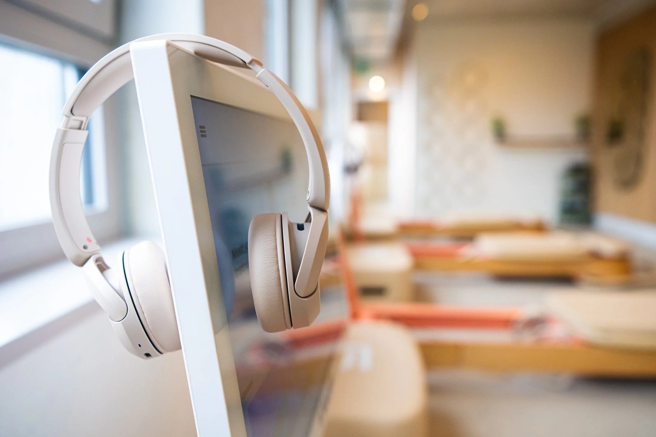 Personal audio headphones mounted on a digital display screen in the reformer pilates area in Zurich Nord.