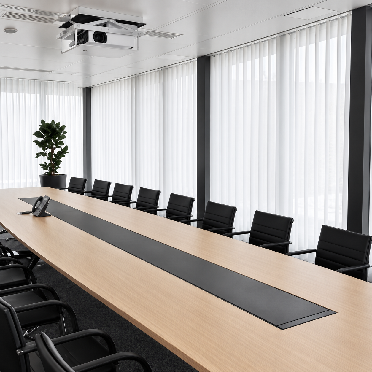 Leerer Konferenzraum mit langem Tisch, schwarzen Stühlen und großen Fenstern mit weißen Vorhängen.