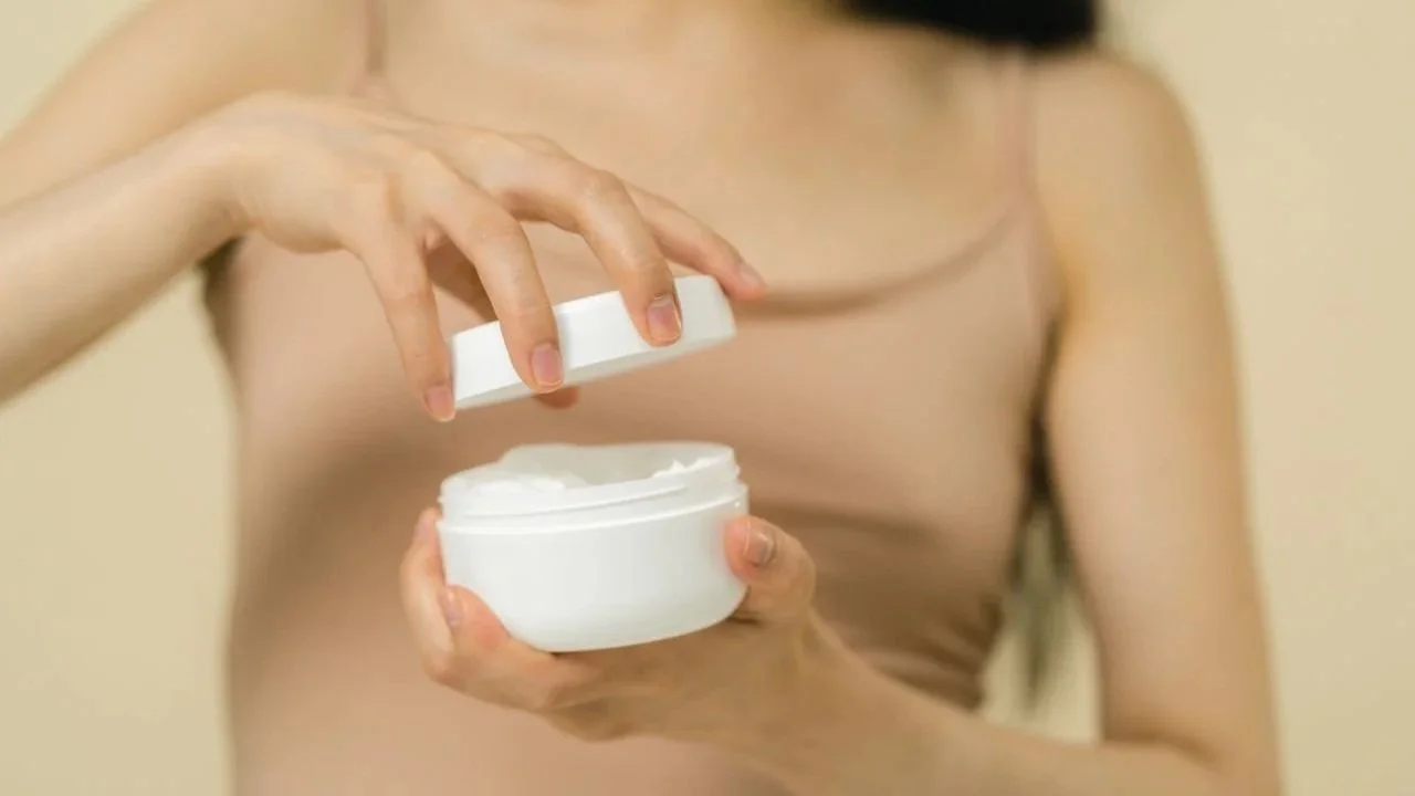 Woman holding a container of skincare product