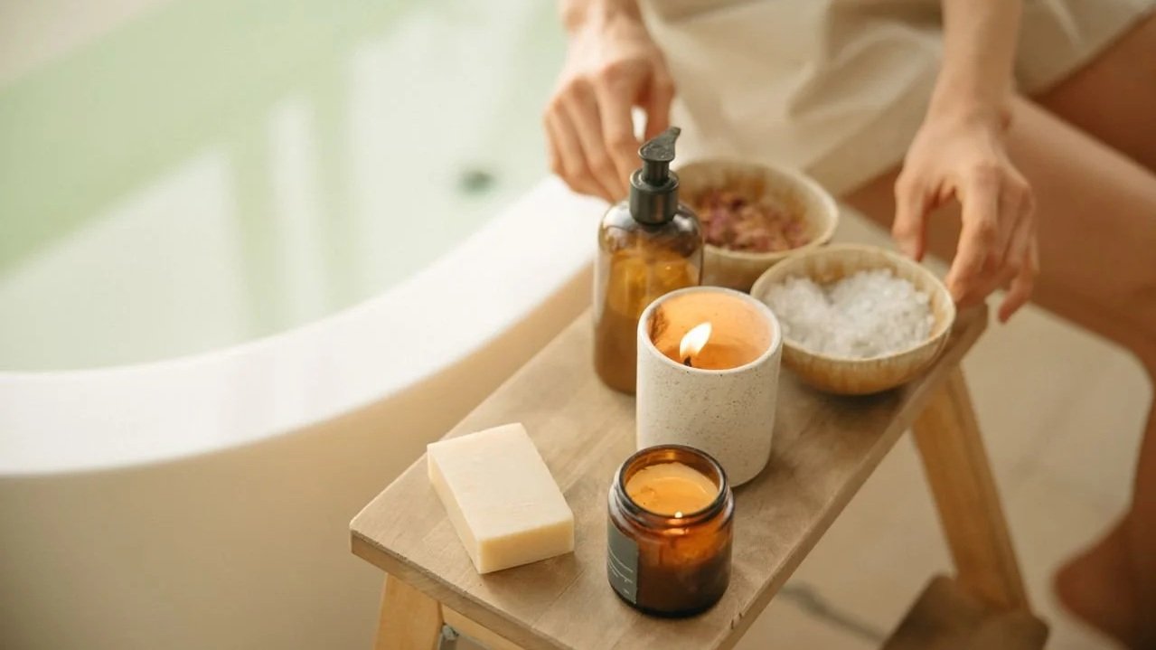 Bath products and skincare essentials arranged beside a bathtub
