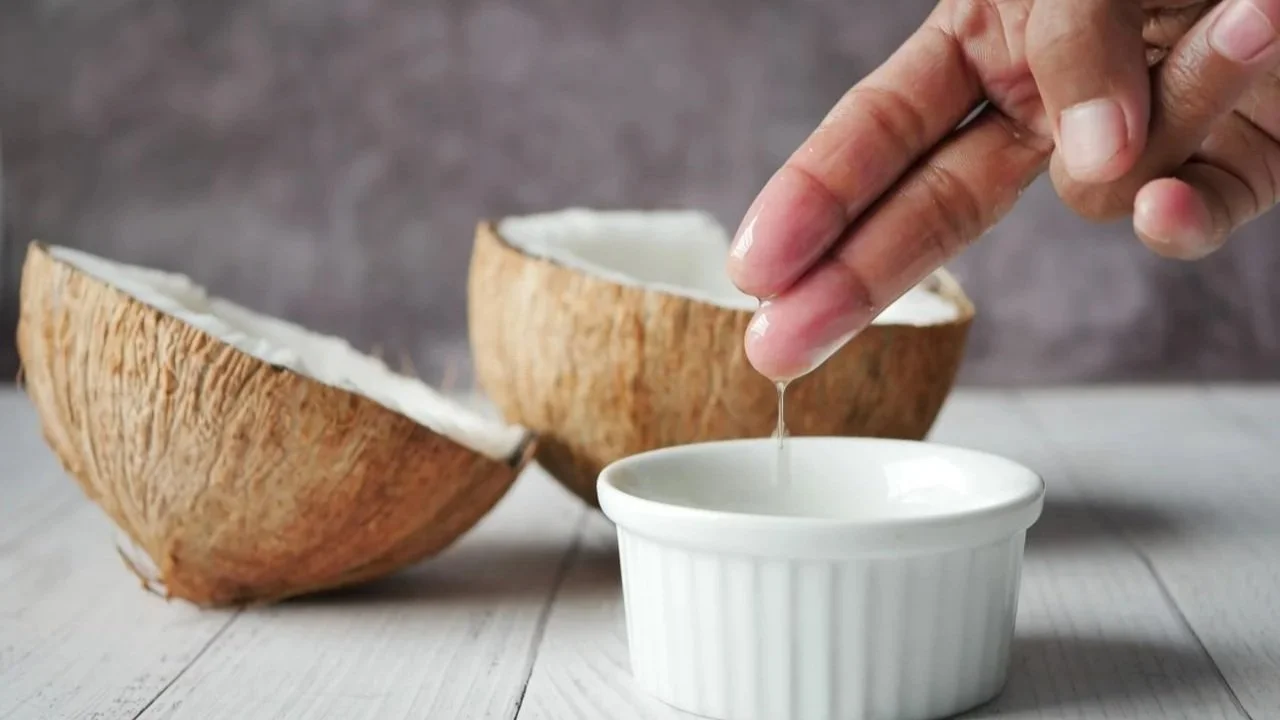 Coconut oil being poured into a small bowl