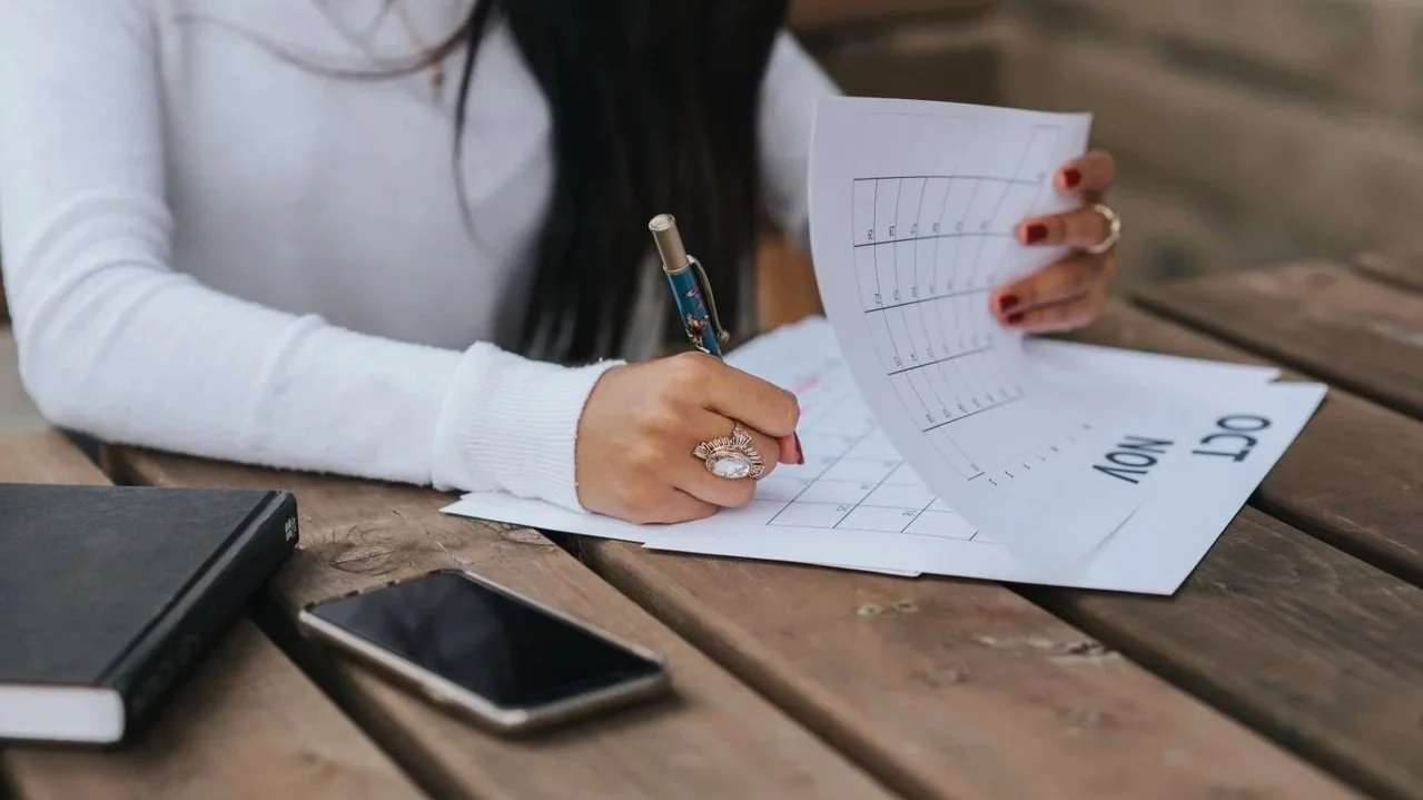 Person marking dates on a calendar