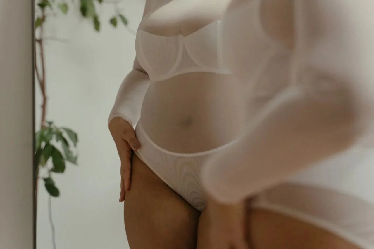 Woman in white lingerie looking in the mirror