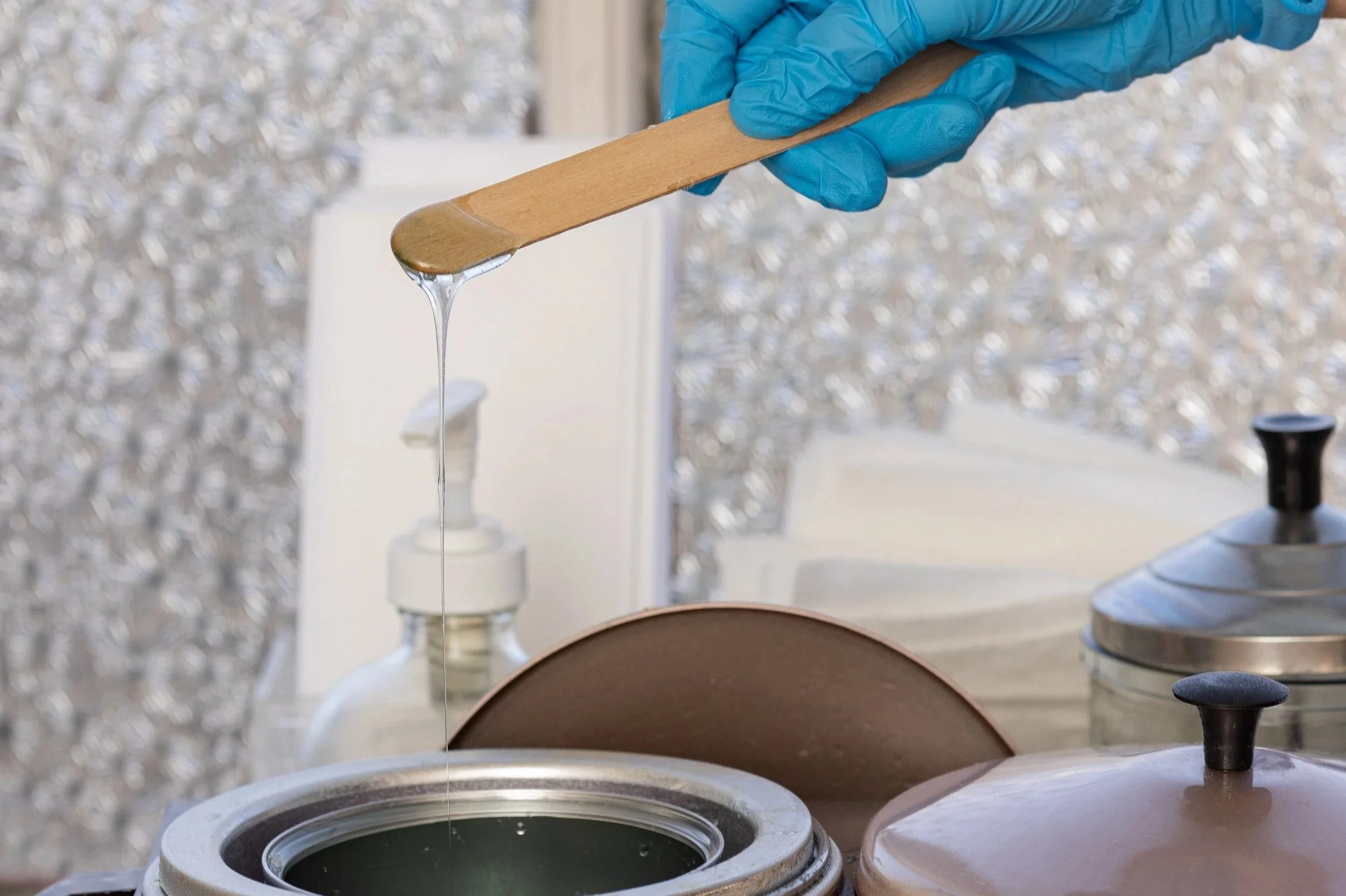 Professional waxing setup with warm wax and applicator stick