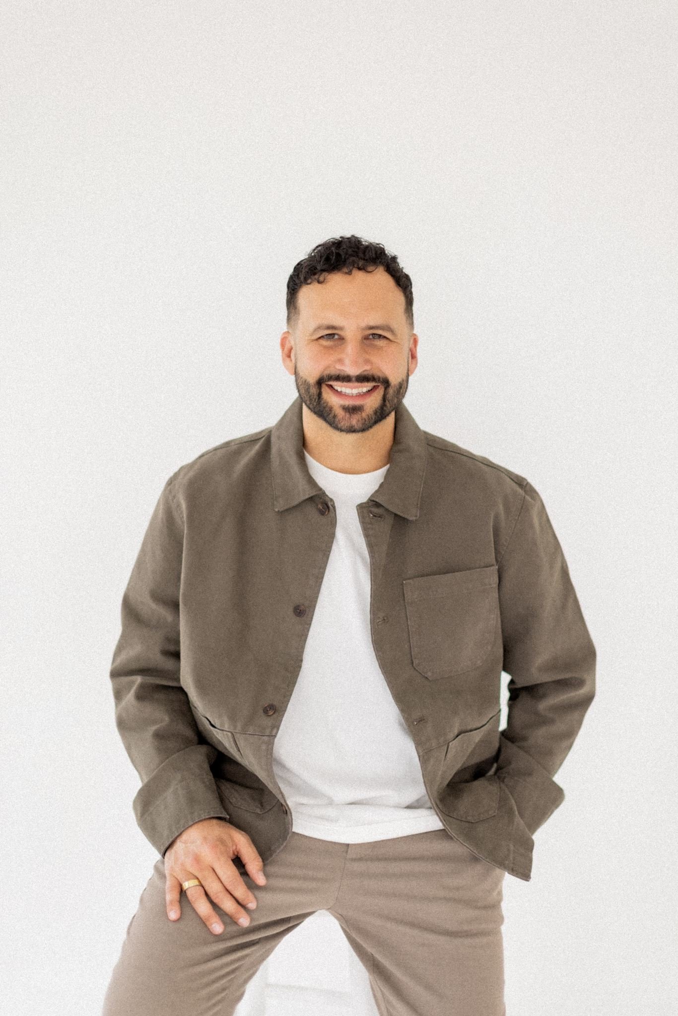 Mike Signorelli smiling in a khaki jacket against a white background.