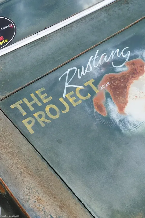 Capot de Ford Mustang avec 'The Rustang Project 2023' peint à la main en jaune et blanc avec patine rouillée.