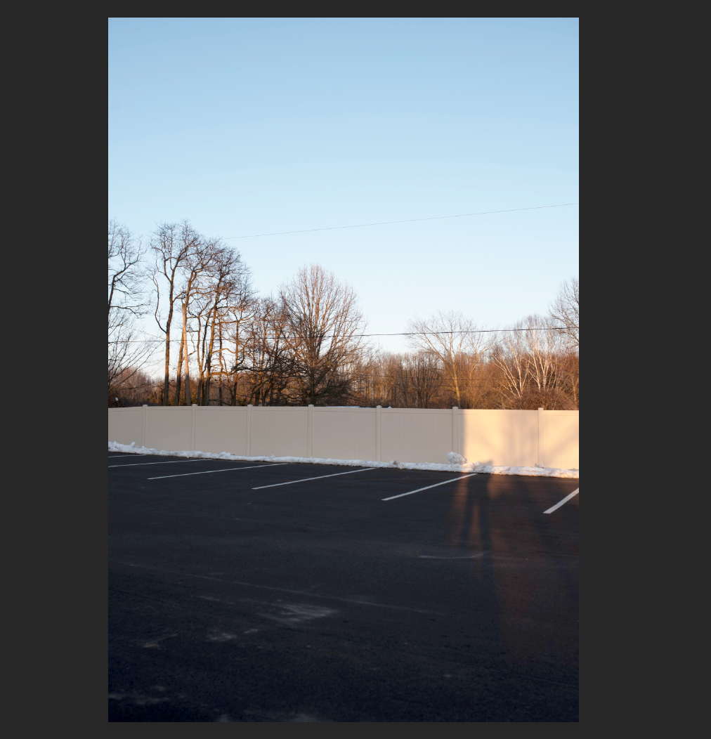 18 paved parking spots surrounded by new privacy fencing.