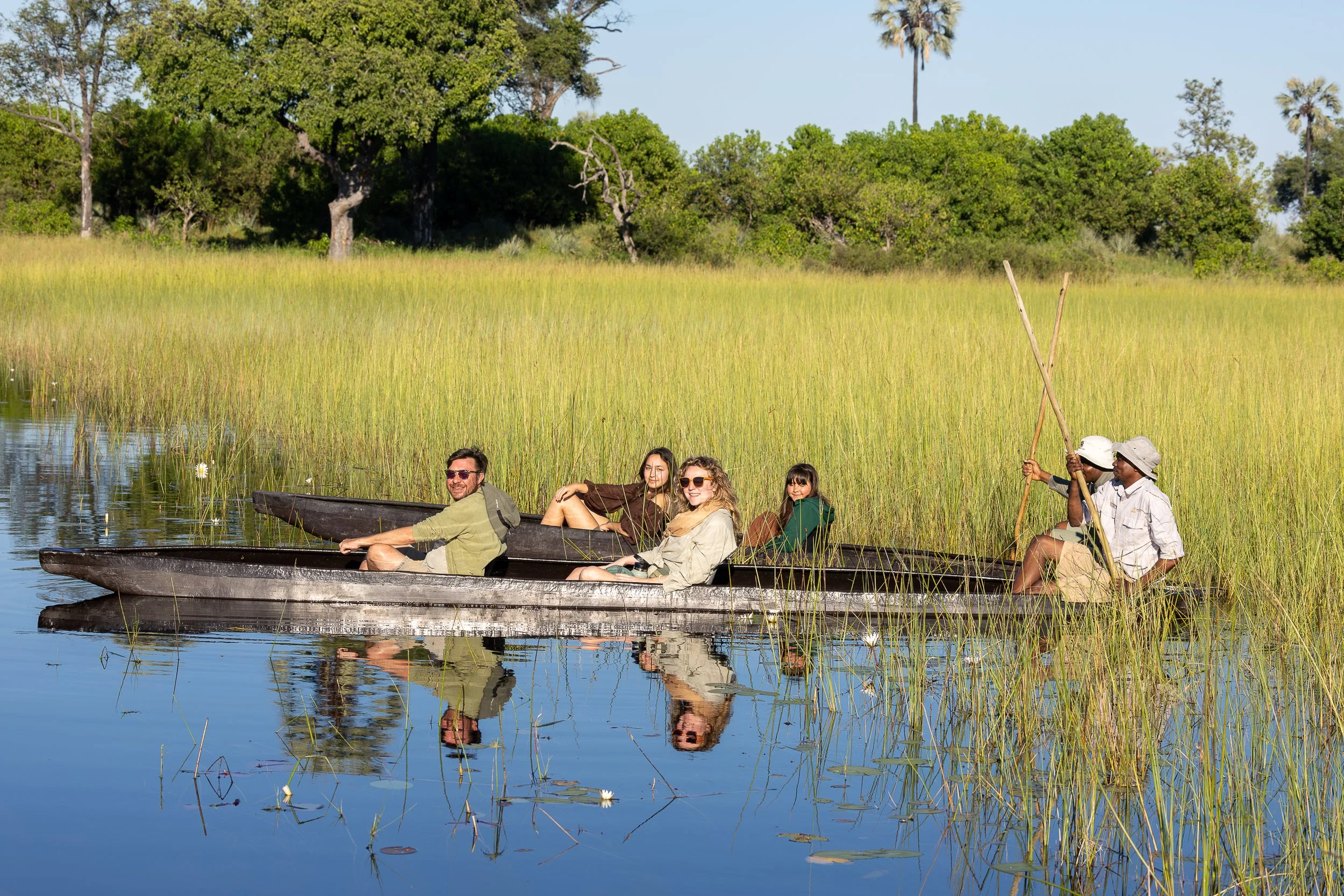 Guests exploring Botswana’s Okavango Delta by mokoro during a hosted safari