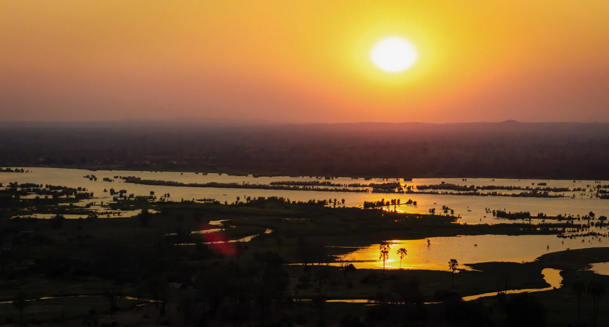 Aerial photograph of sunset over the Shire River in Liwonde National Park, Malawi, with the river and surrounding landscape illuminated by the evening light.