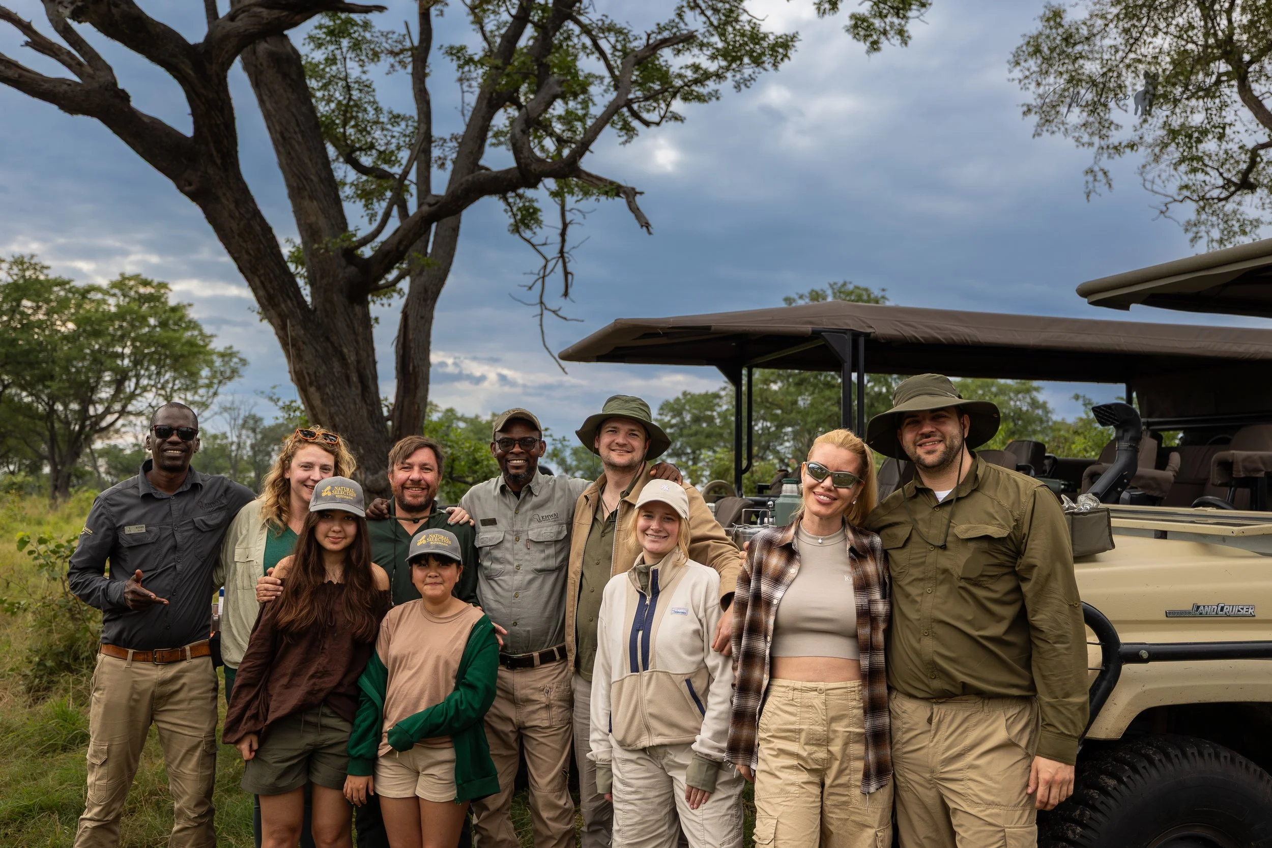 WildLens Adventures guests and local guides beside a safari vehicle at Little Sable in Botswana