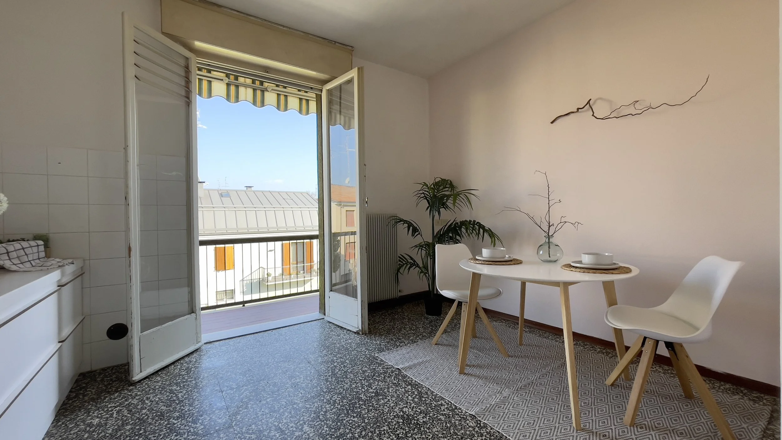 Cucina moderna con tavolo rotondo e due sedie bianche.
