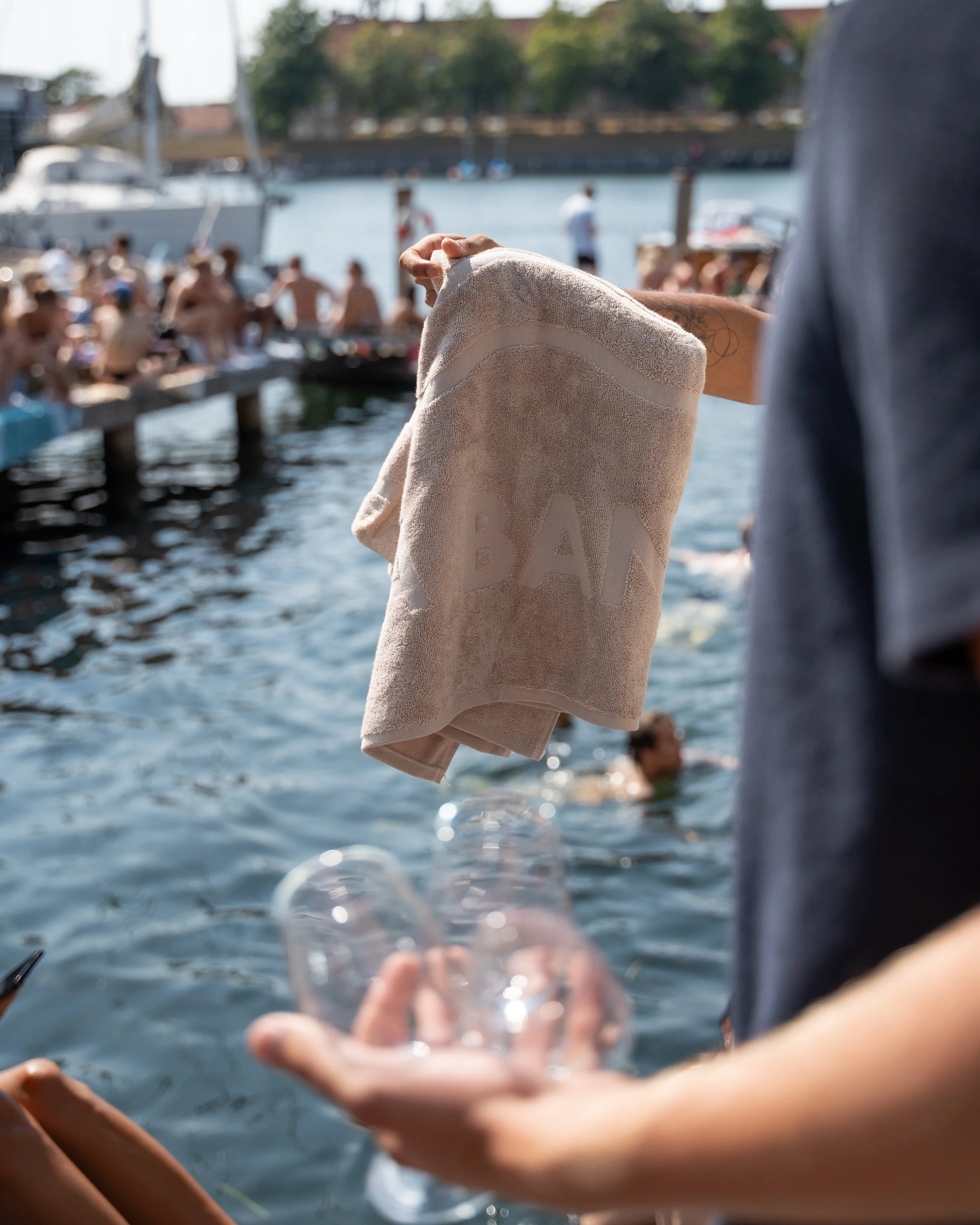 La Banchina towel near at a swimming dock in copenhagen and people in the background.