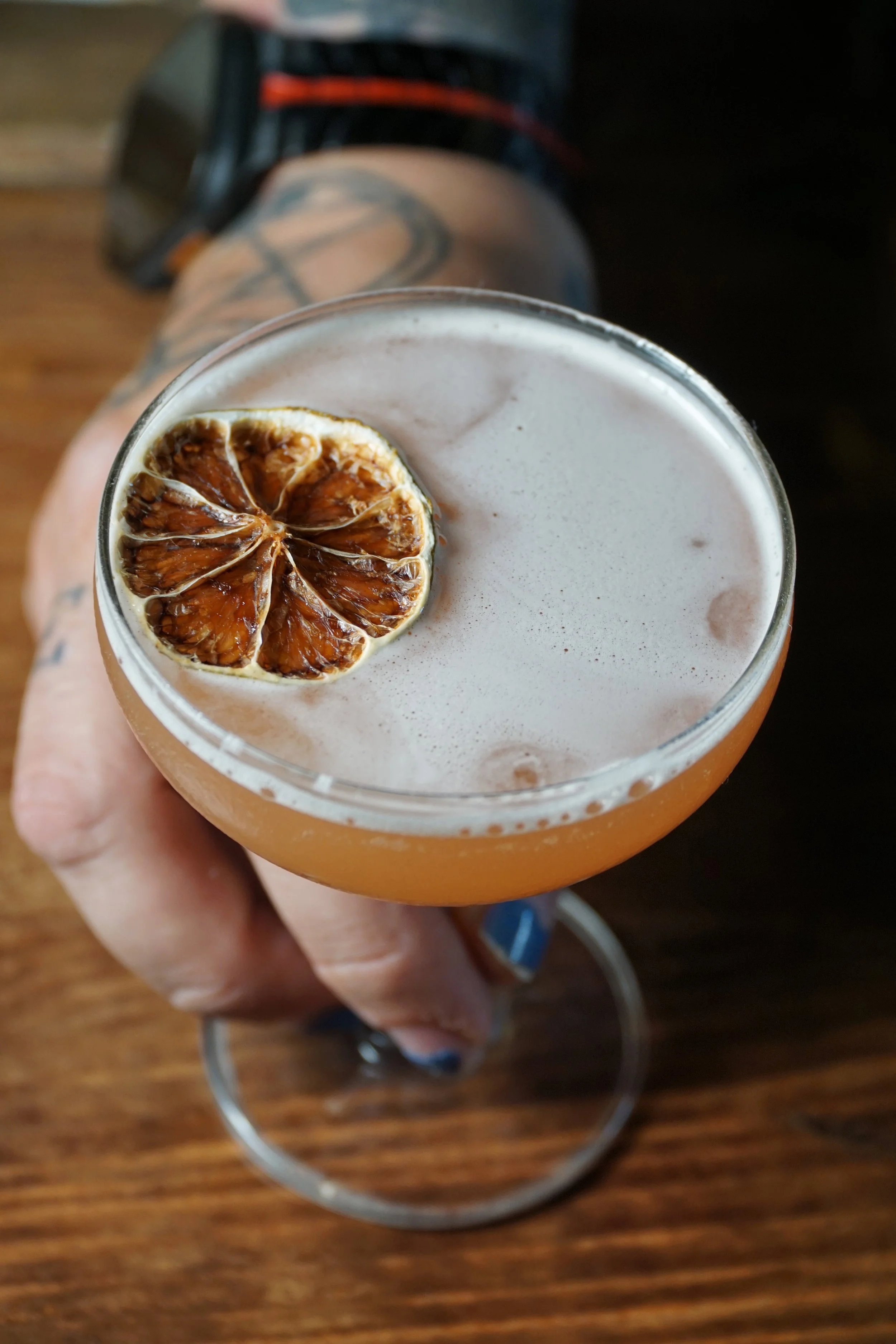 A cocktail with a dried citrus slice garnish, viewed from above.