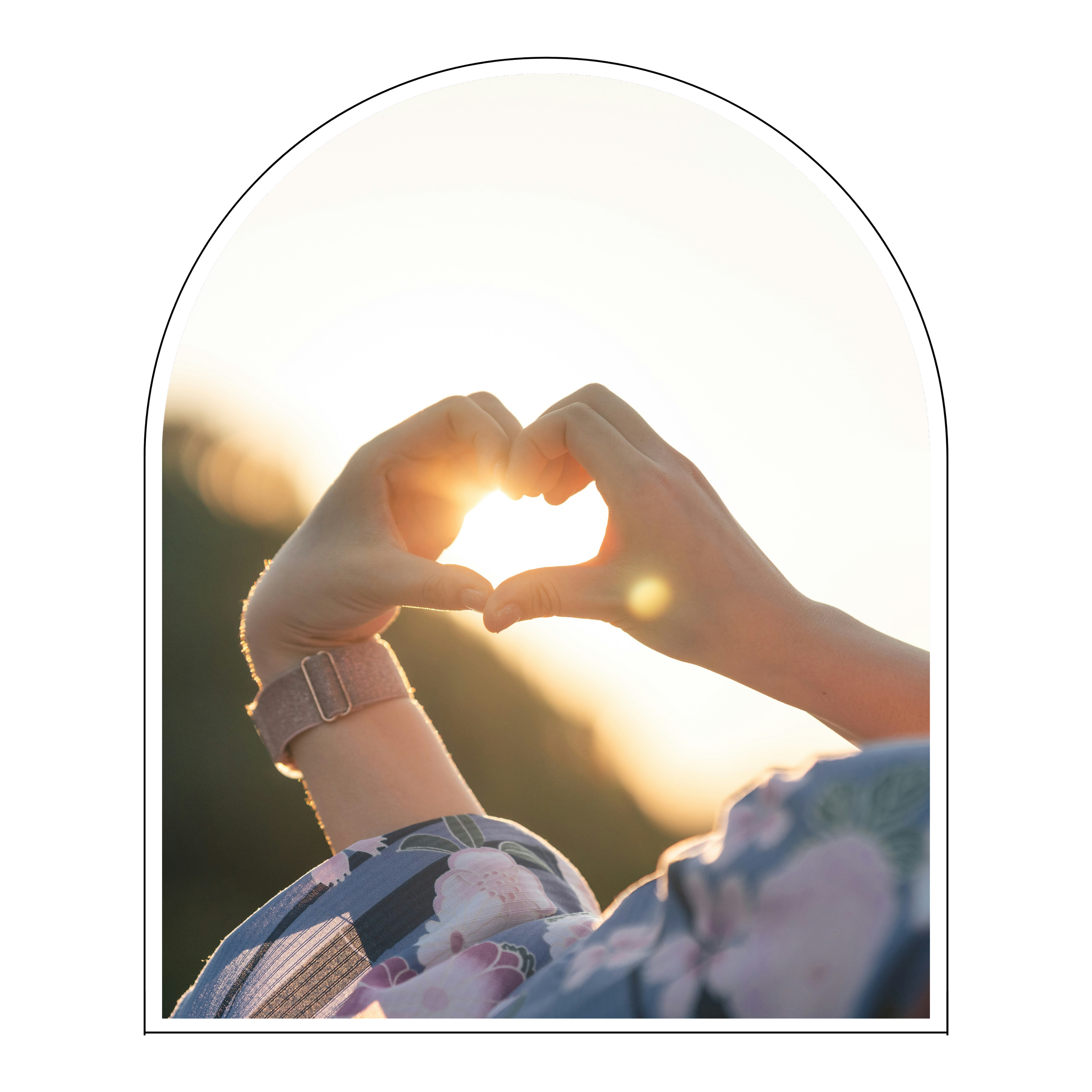 Hands forming a heart shape with the sunset in the background.