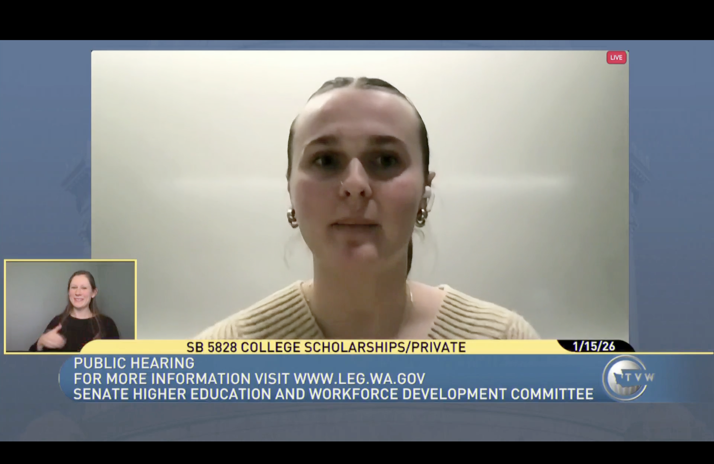 A woman with dark hair tied back is speaking during a live online public hearing about college scholarships, with a sign language interpreter in the bottom left corner, and a banner at the bottom with details about the hearing and relevant website.