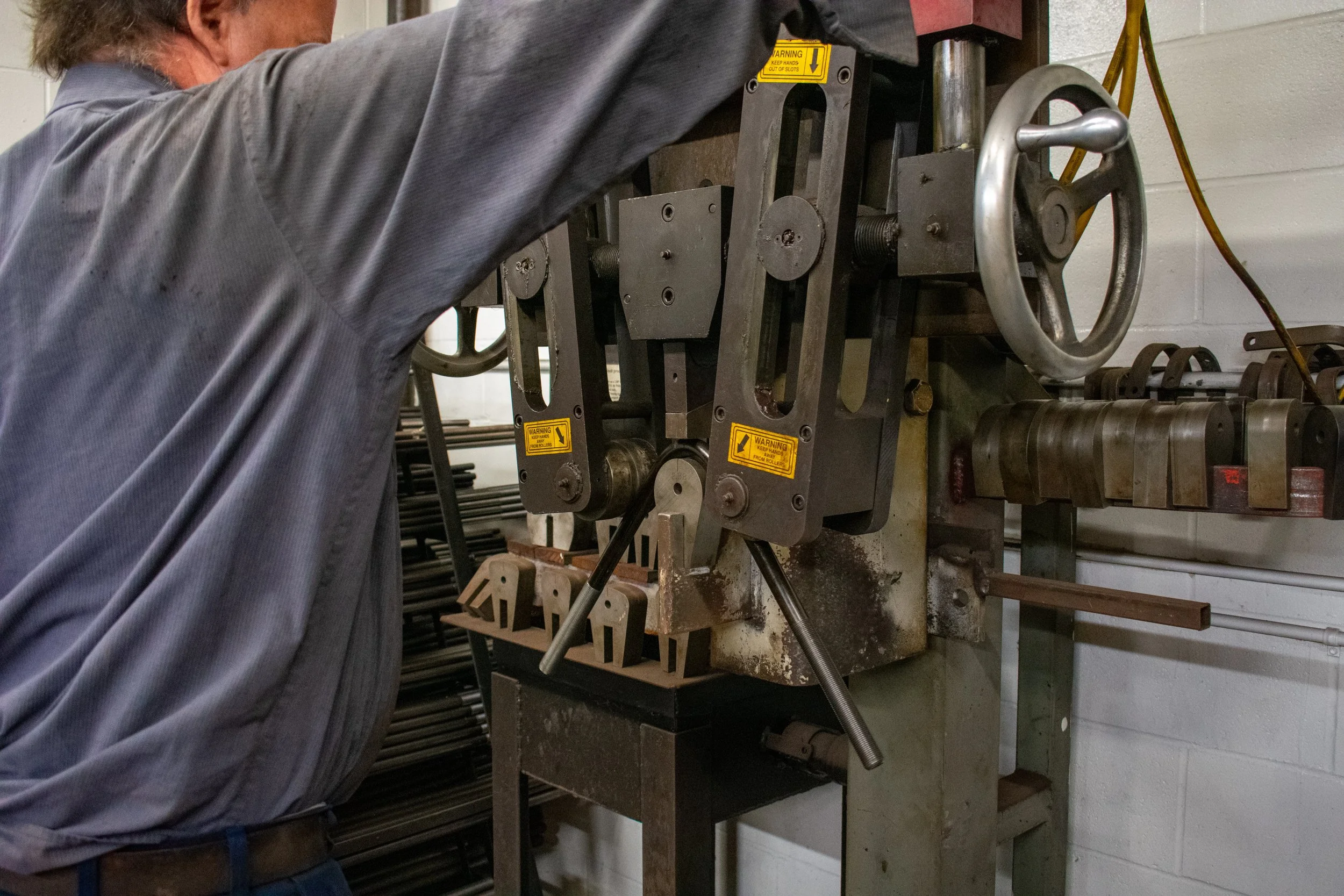 A person operating a metalworking machine in a workshop.
