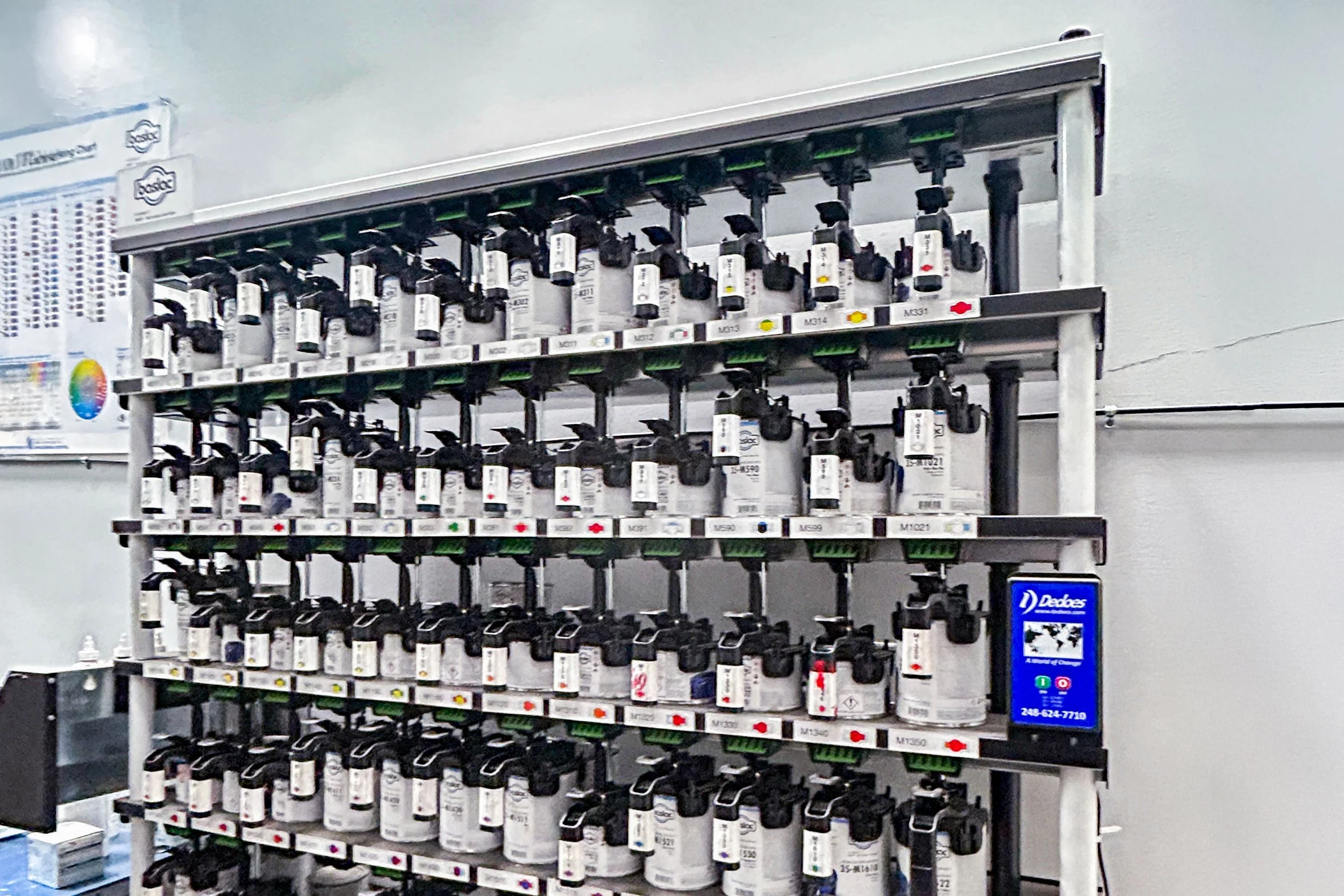 A retail shelf displaying various bottles of automotive paint in a hardware store.