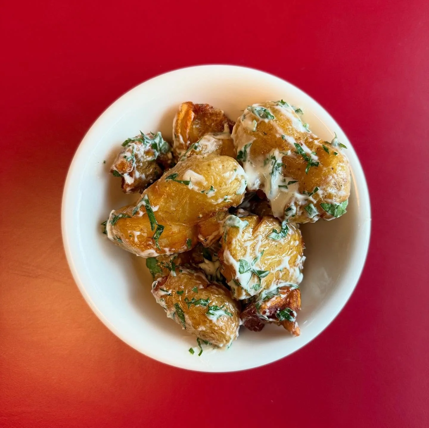 Our Ratte potatoes are roughed up and deep fried then tossed in loads of garlicky aioli, a side dish of dreams! 

Crunchy exterior, fluffy interior smothered in the rich punchy mayonnaise, keep them coming!