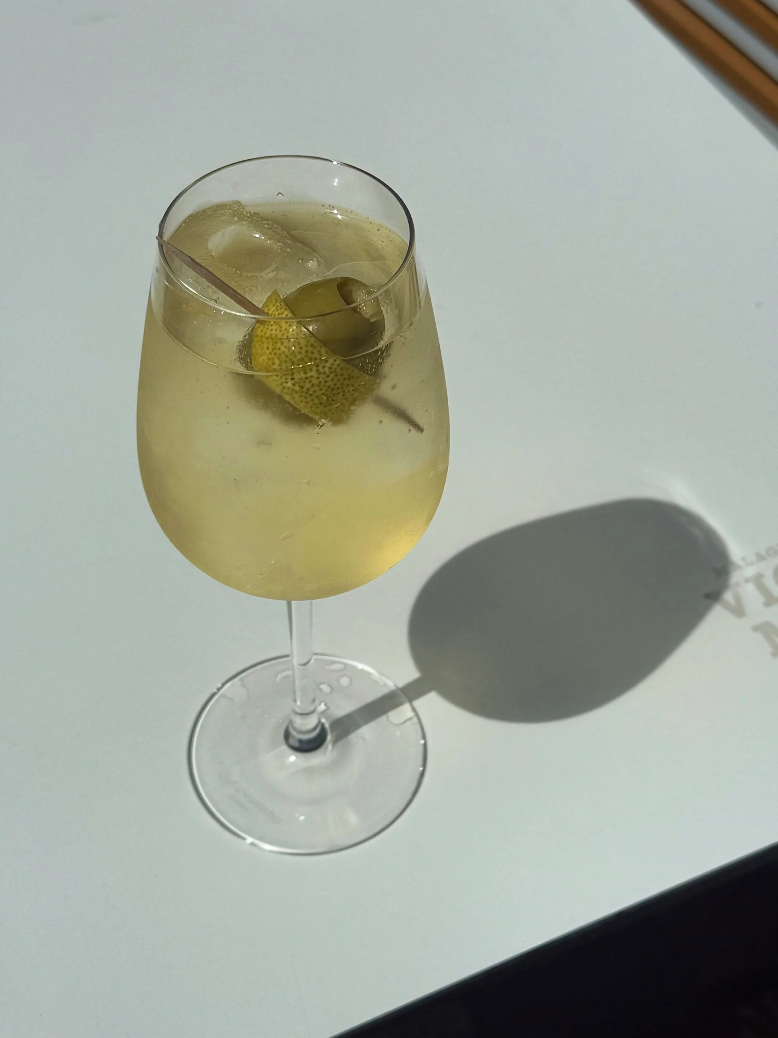 White Negroni Spritz with lemon wrapped olive 🫒